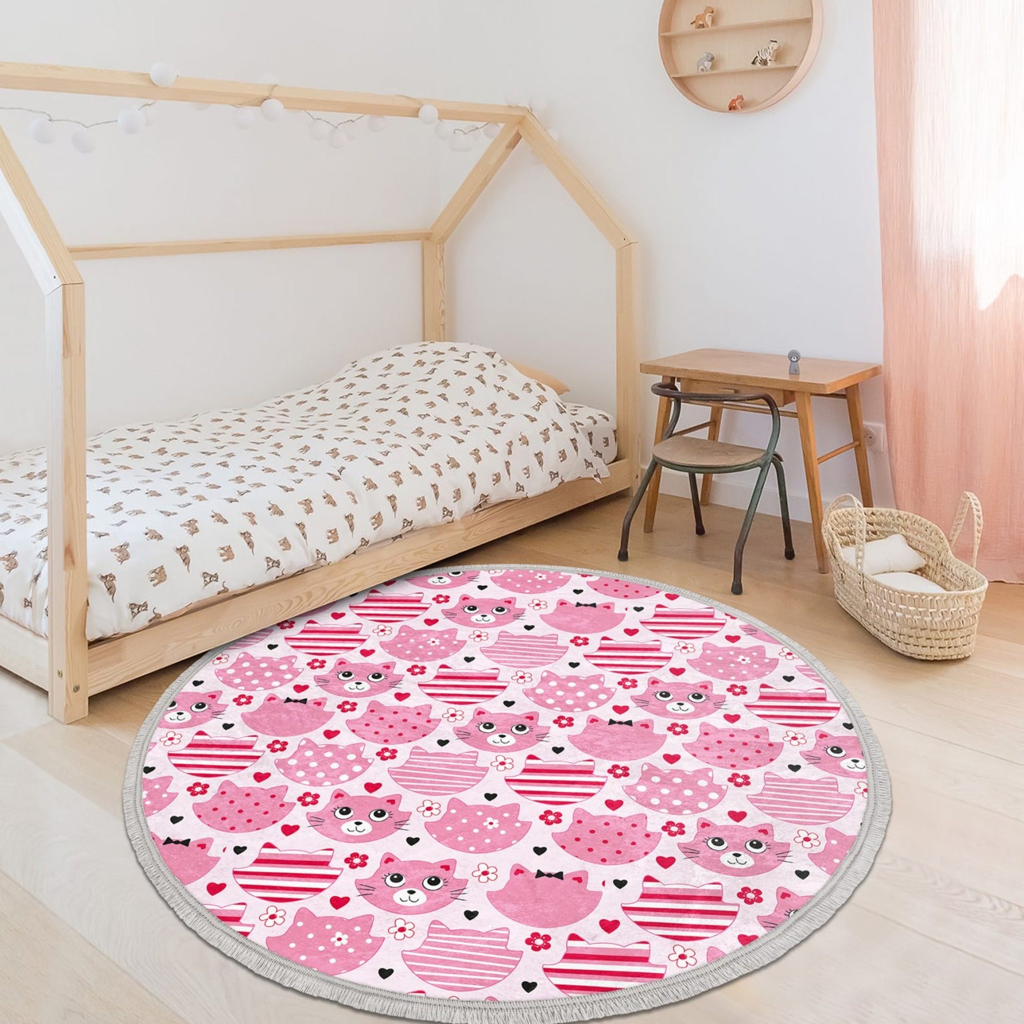 A round pink cat nursery rug featuring a cute cat design, made of shiny velvet fabric, perfect for kids' rooms.