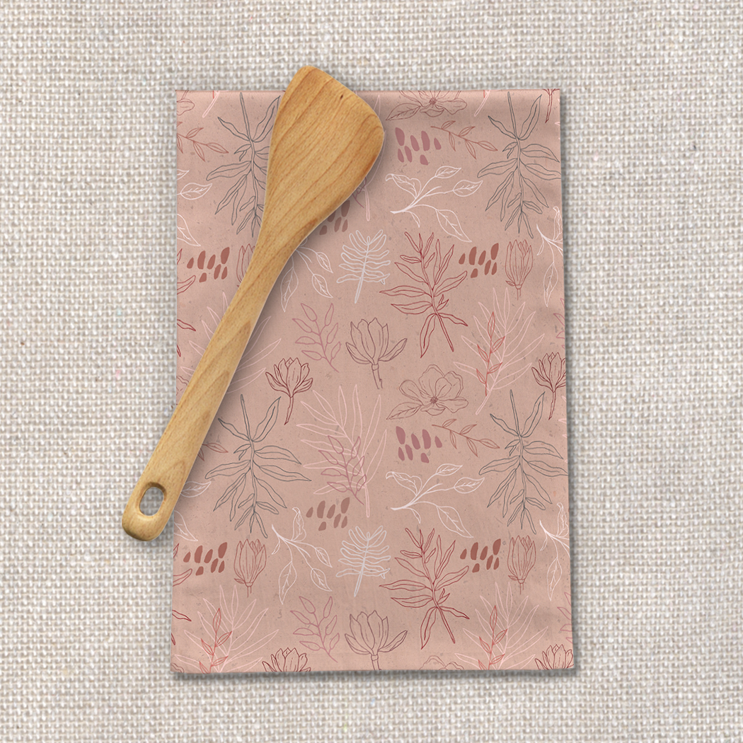 A pink tea towel featuring a desert leaf design, made from cotton twill, perfect for kitchen use.