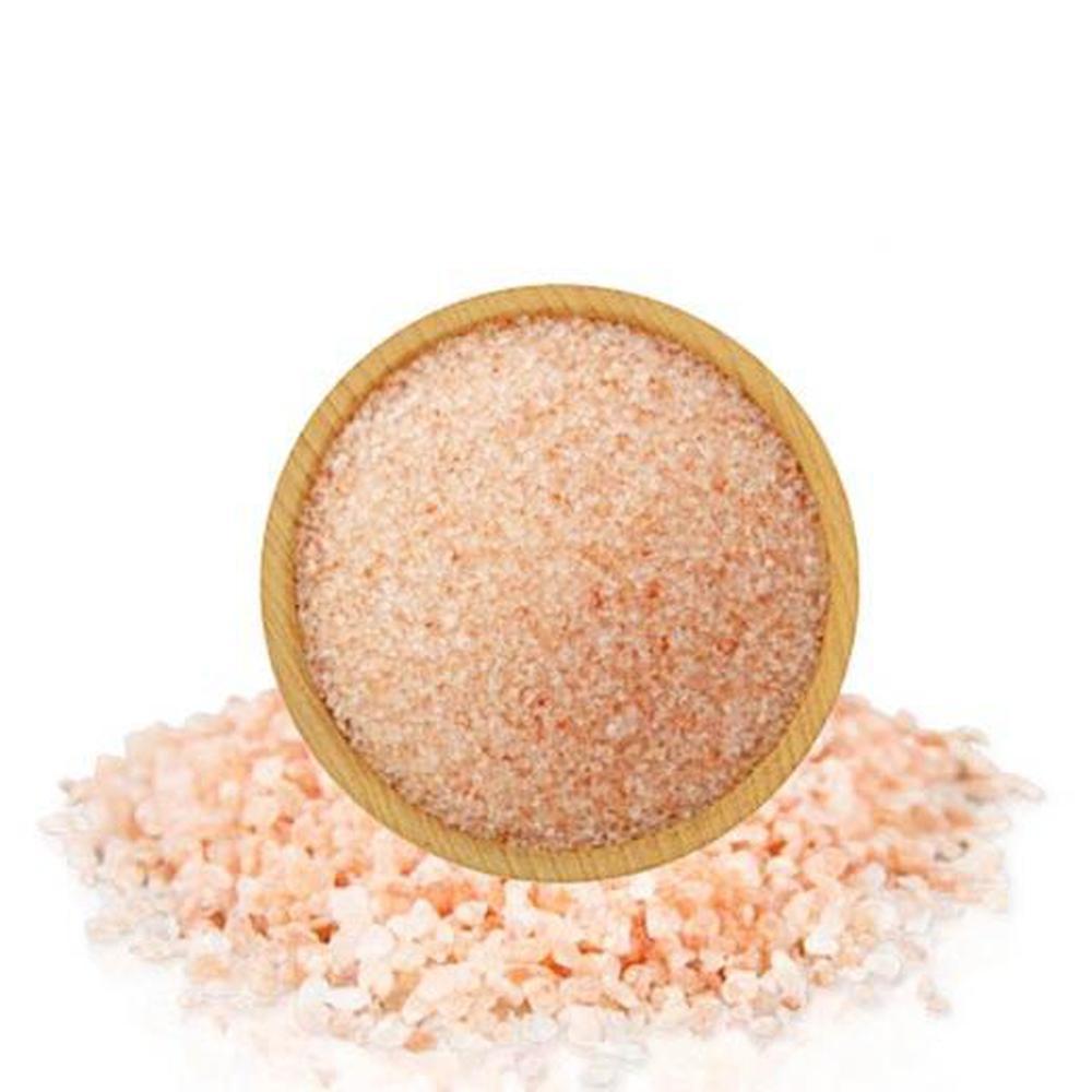 A bowl of pink Himalayan bath salts with natural crystal rocks, showcasing their coarse texture and vibrant color.