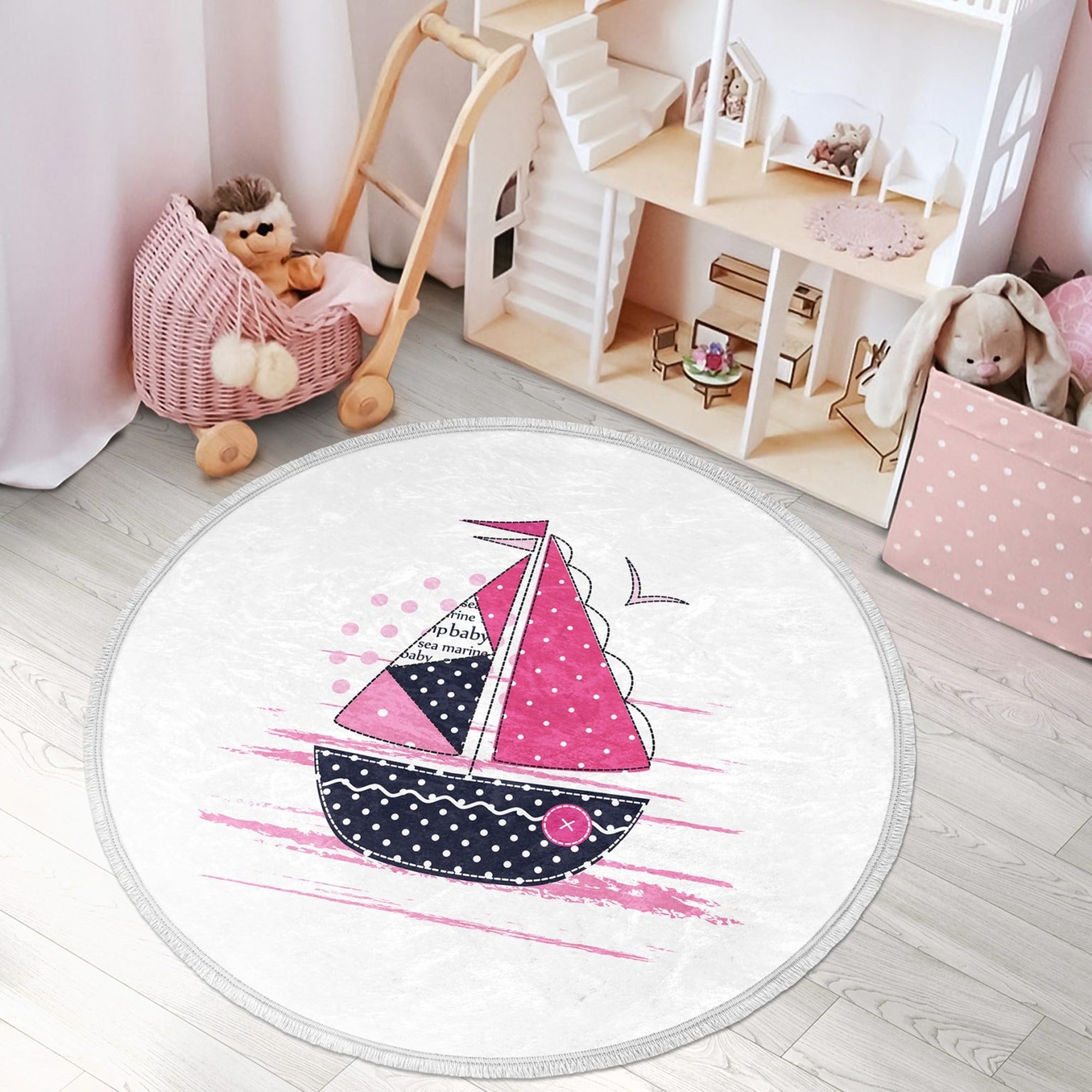 A vibrant pink round rug featuring a marine sailboat design, perfect for kids' rooms and nurseries.