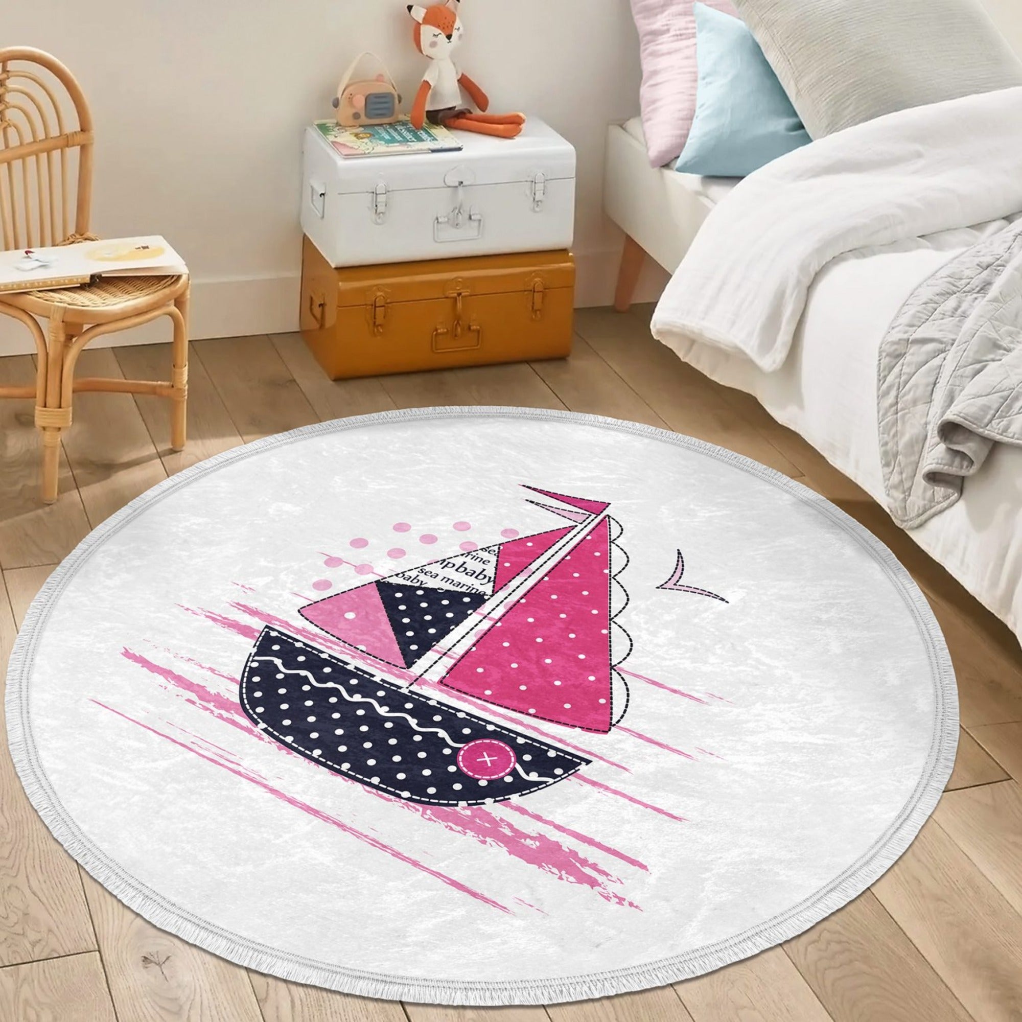 A vibrant pink round rug featuring a marine sailboat design, perfect for kids' rooms and nurseries.