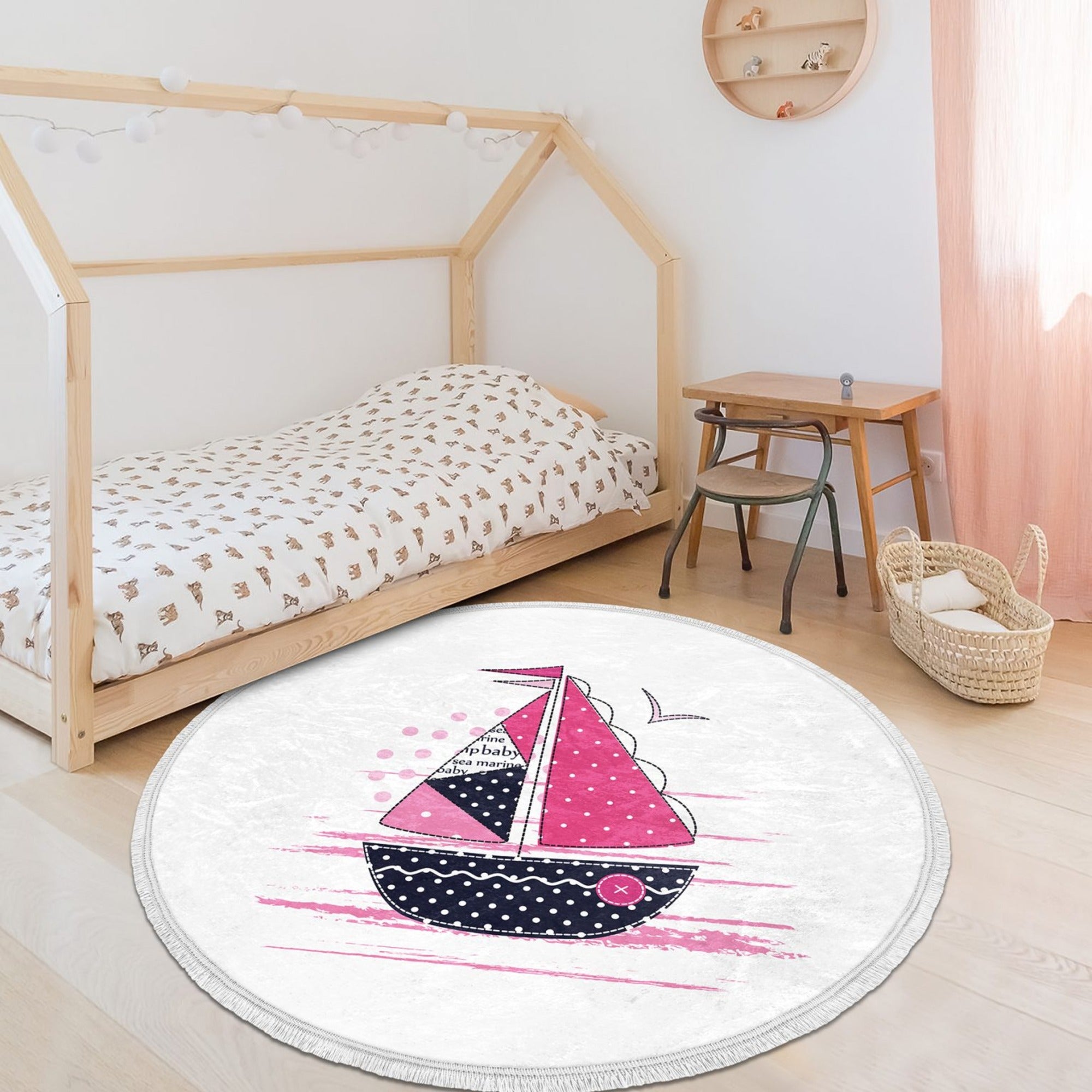 A vibrant pink round rug featuring a marine sailboat design, perfect for kids' rooms and nurseries.