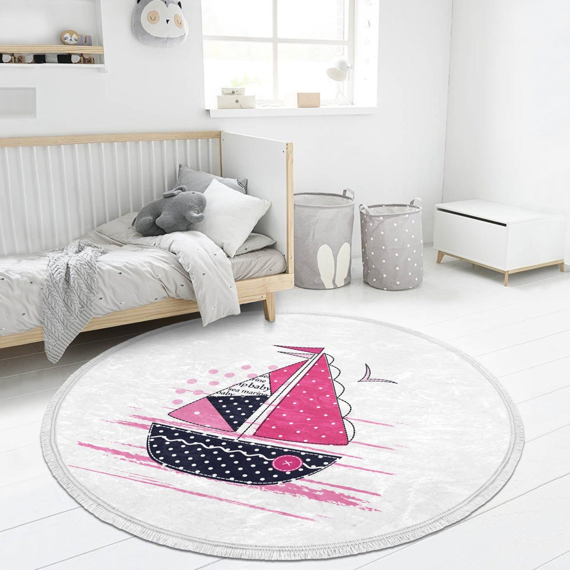 A vibrant pink round rug featuring a marine sailboat design, perfect for kids' rooms and nurseries.