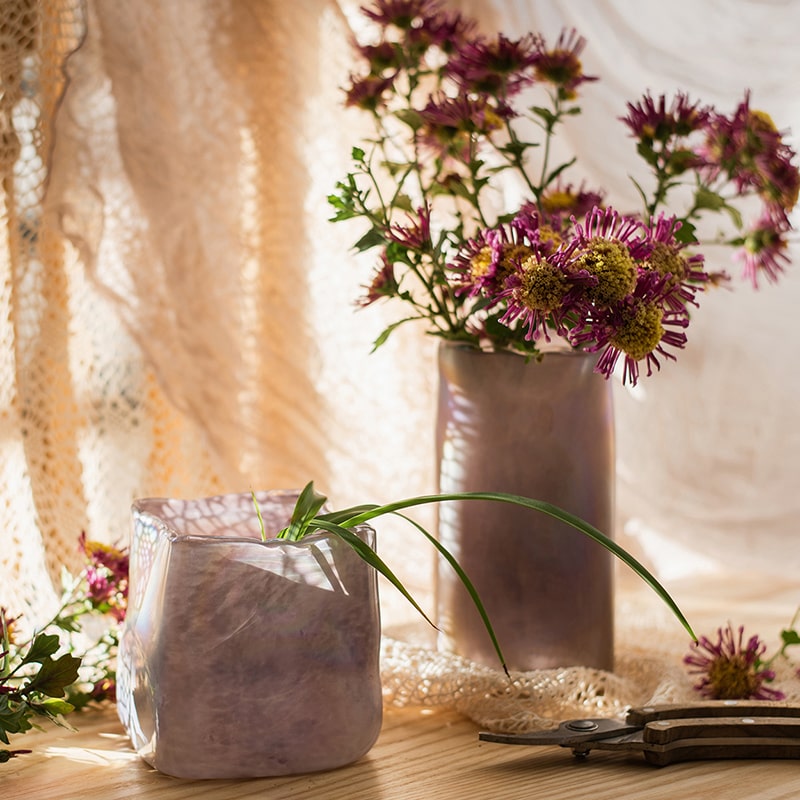 A beautiful hand-blown glass vase in pink Morandi color, showcasing unique shapes and colors, perfect for floral arrangements.