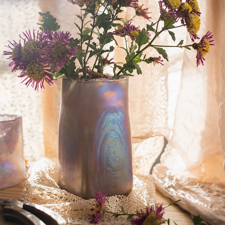 A beautiful hand-blown glass vase in pink Morandi color, showcasing unique shapes and colors, perfect for floral arrangements.