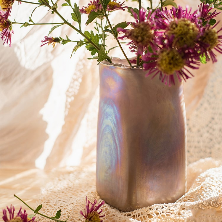 A beautiful hand-blown glass vase in pink Morandi color, showcasing unique shapes and colors, perfect for floral arrangements.