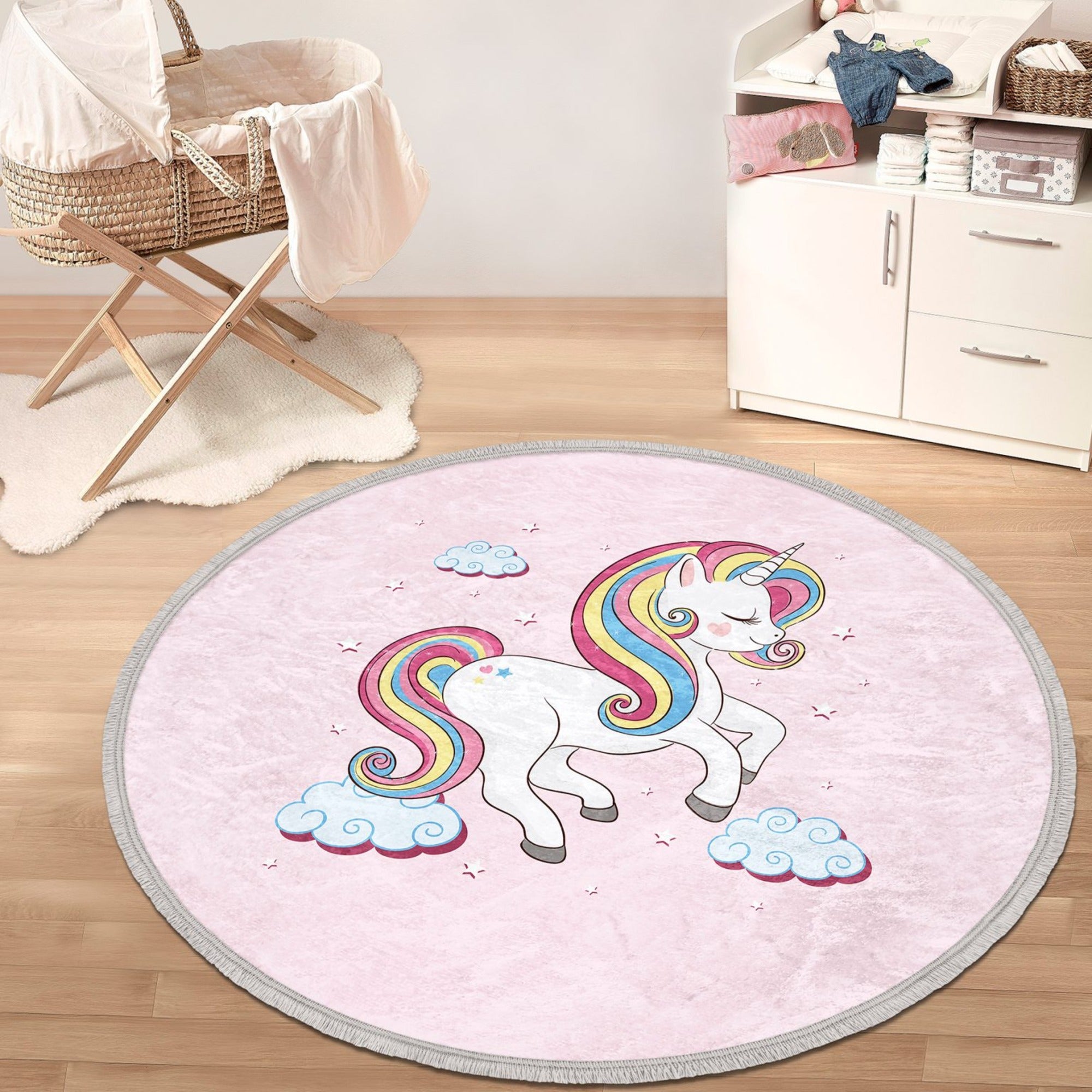 A round pink rug featuring a whimsical unicorn pattern, perfect for a girl's room, showcasing its soft velvet texture and fringes.