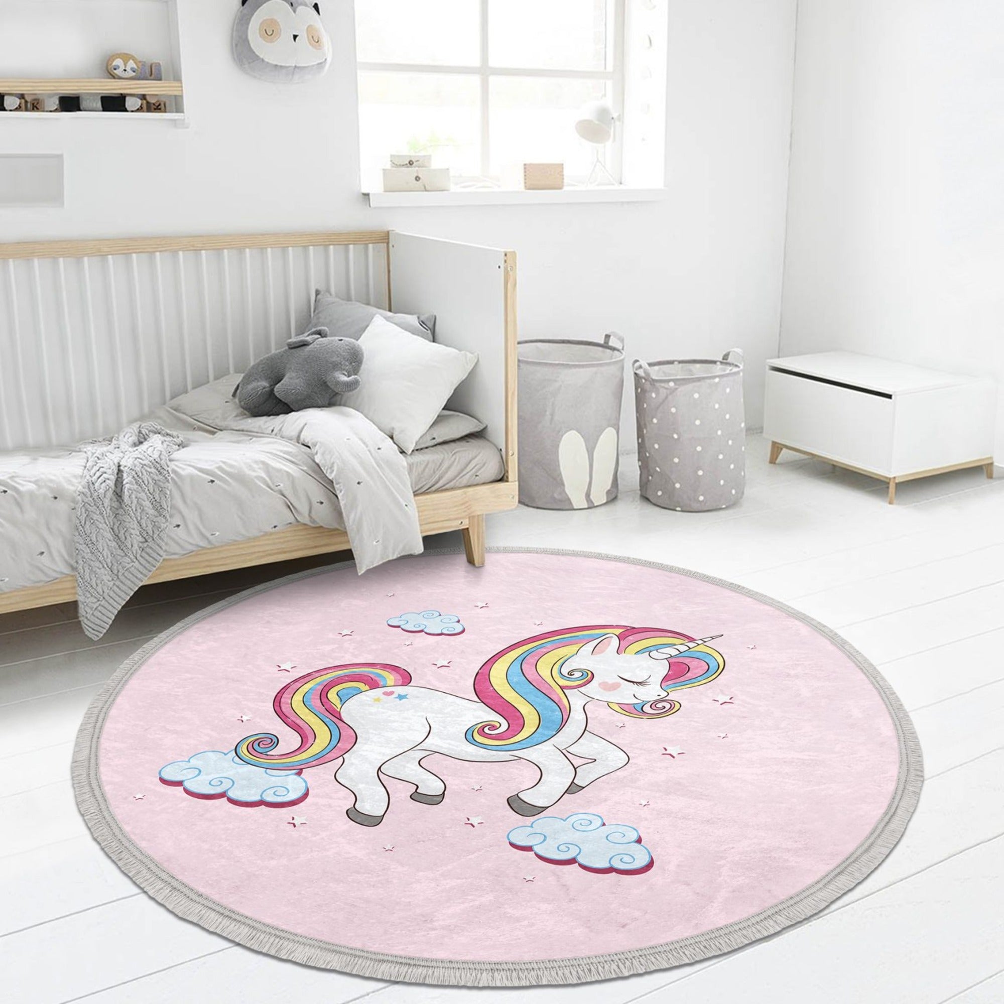 A round pink rug featuring a whimsical unicorn pattern, perfect for a girl's room, showcasing its soft velvet texture and fringes.