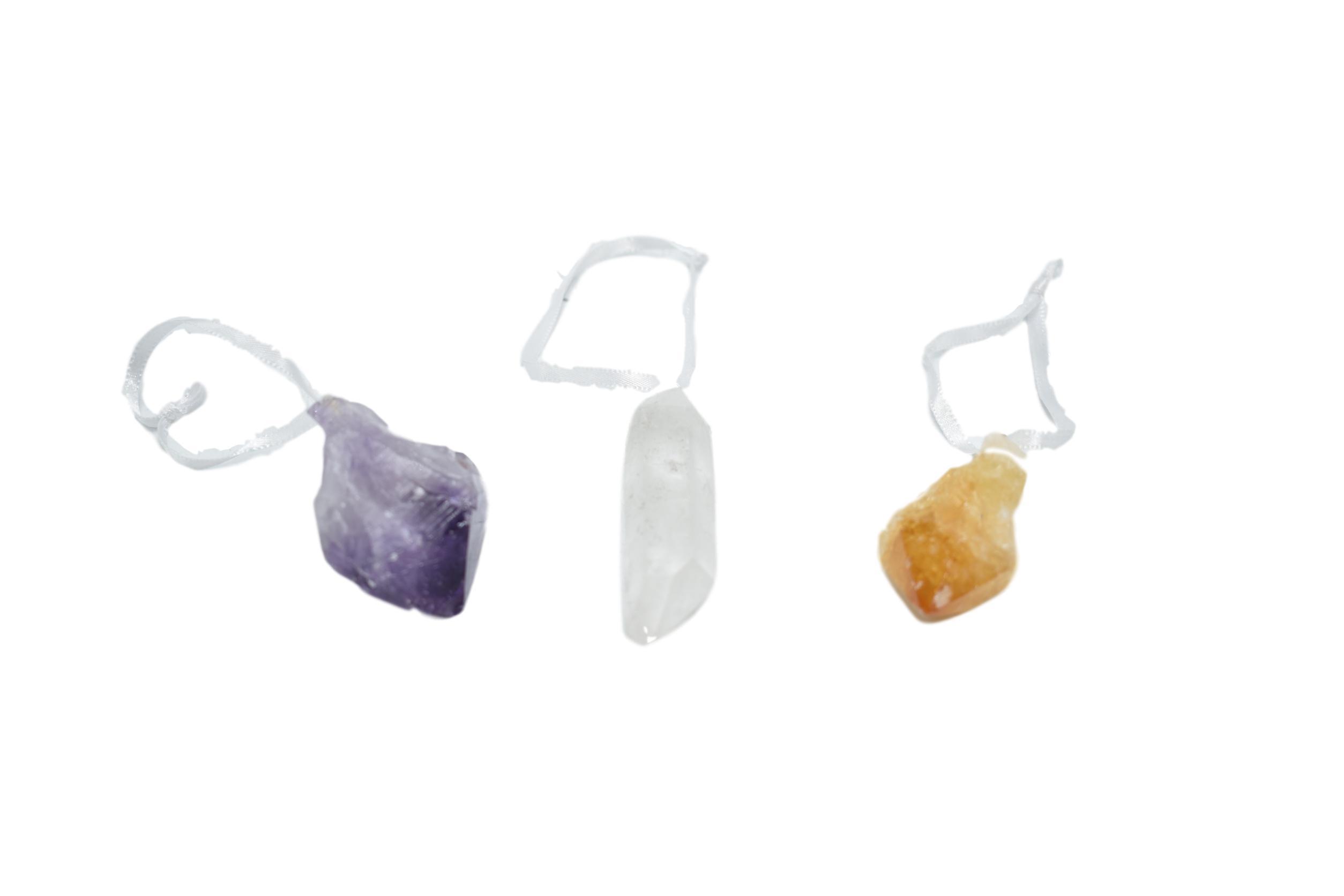 A collection of raw crystal points in amethyst, white quartz, and citrine, each with a natural trim and white ribbon for hanging.