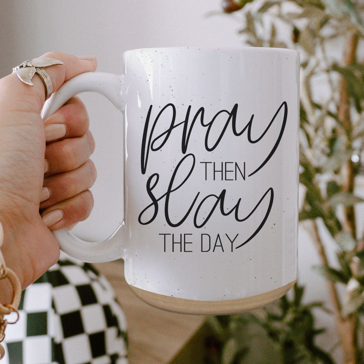 Pray + Slay 16oz ceramic mug with black graphic design on both sides, off-white color with dark speckles.