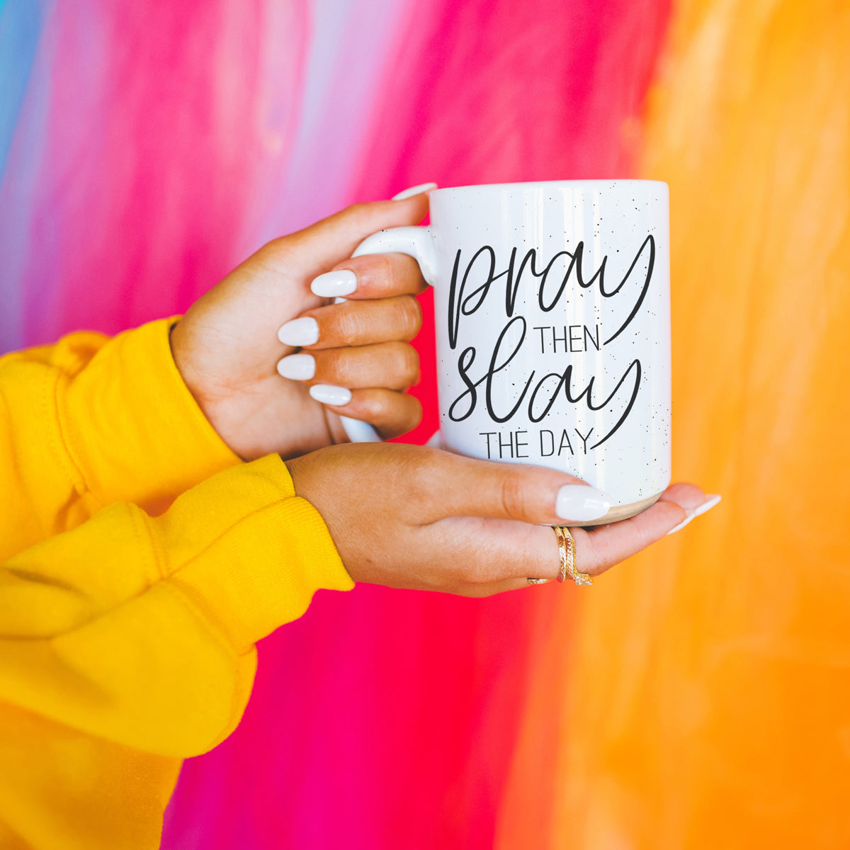 Pray + Slay 16oz ceramic mug with black graphic design on both sides, off-white color with dark speckles.