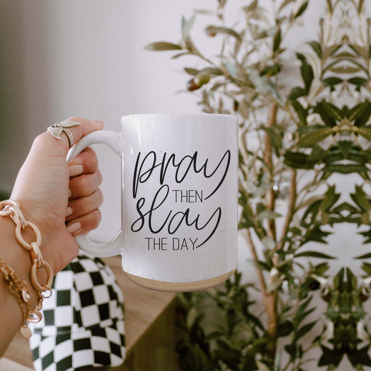 Pray + Slay 16oz ceramic mug with black graphic design on both sides, off-white color with dark speckles.