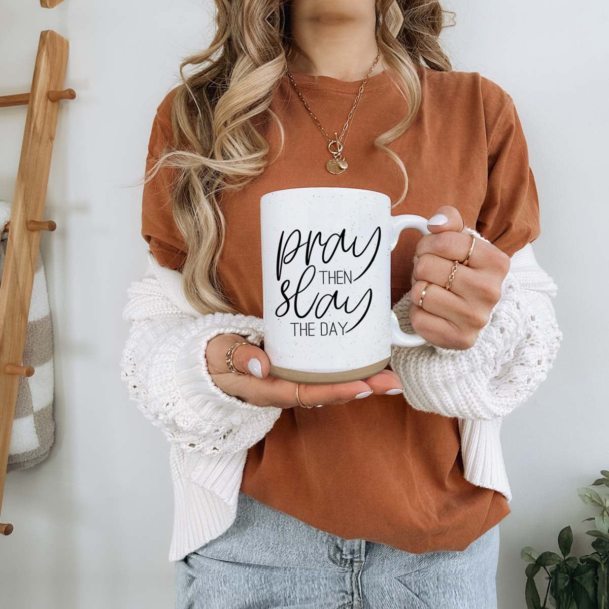 Pray + Slay 16oz ceramic mug with black graphic design on both sides, off-white color with dark speckles.