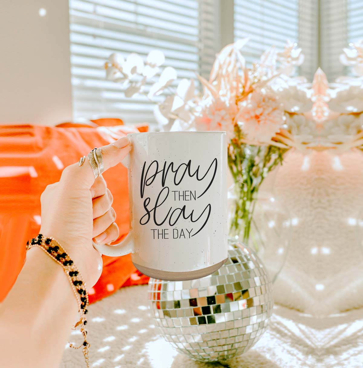 Pray + Slay 16oz ceramic mug with black graphic design on both sides, off-white color with dark speckles.