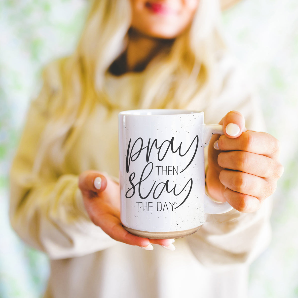 Pray + Slay 16oz ceramic mug with black graphic design on both sides, off-white color with dark speckles.