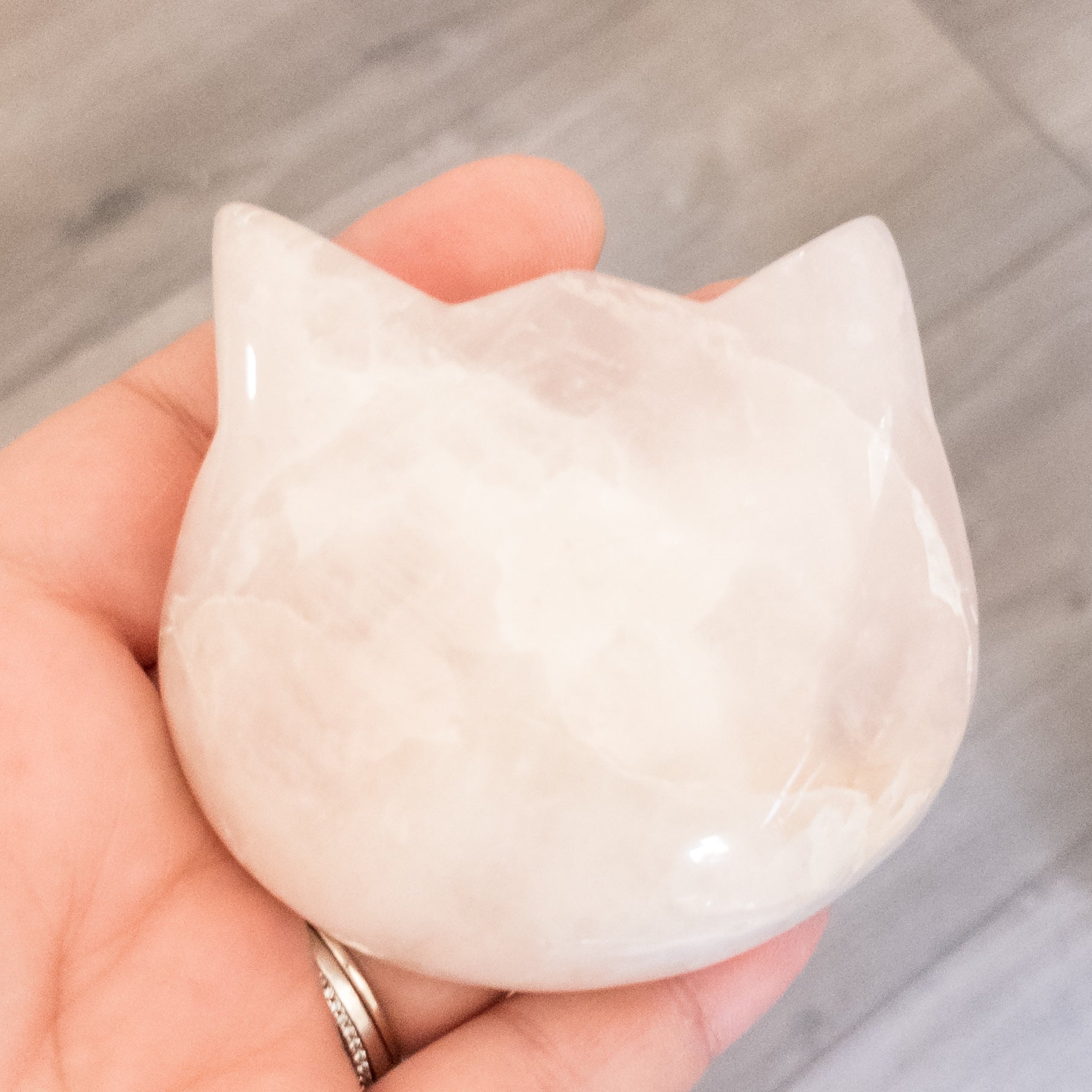 Three hand-polished Puffy Crystal Cat Heads in Black Obsidian, Rose Quartz, and Clear Quartz, showcasing their unique shapes and colors.