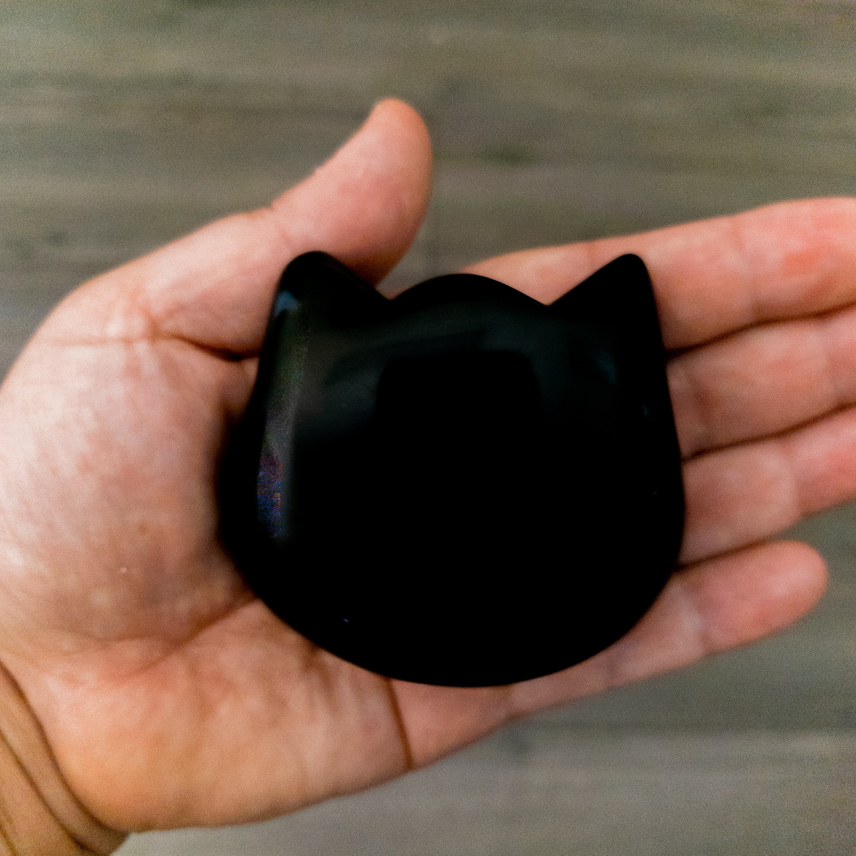 Three hand-polished Puffy Crystal Cat Heads in Black Obsidian, Rose Quartz, and Clear Quartz, showcasing their unique shapes and colors.