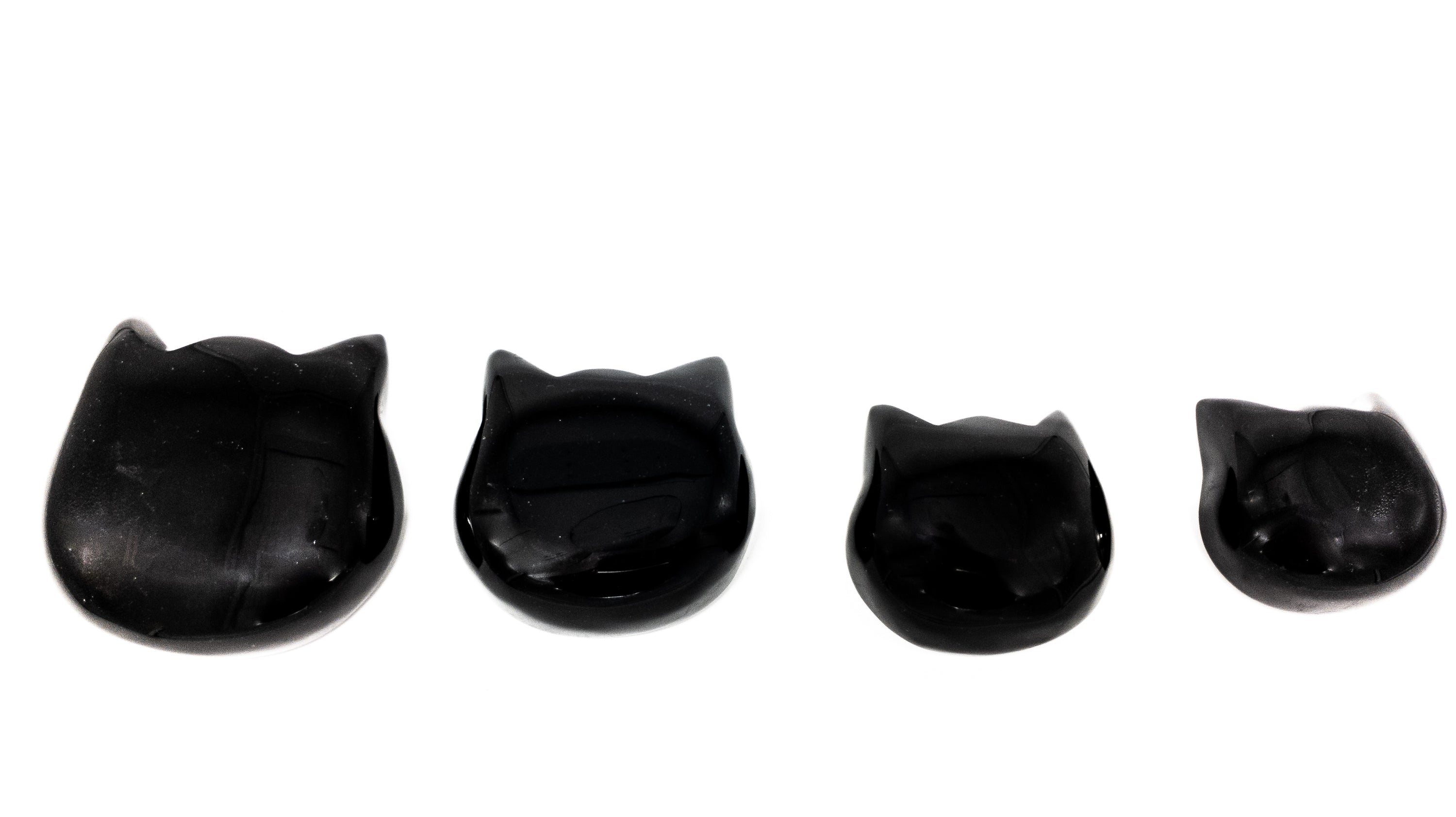 Three hand-polished Puffy Crystal Cat Heads in Black Obsidian, Rose Quartz, and Clear Quartz, showcasing their unique shapes and colors.