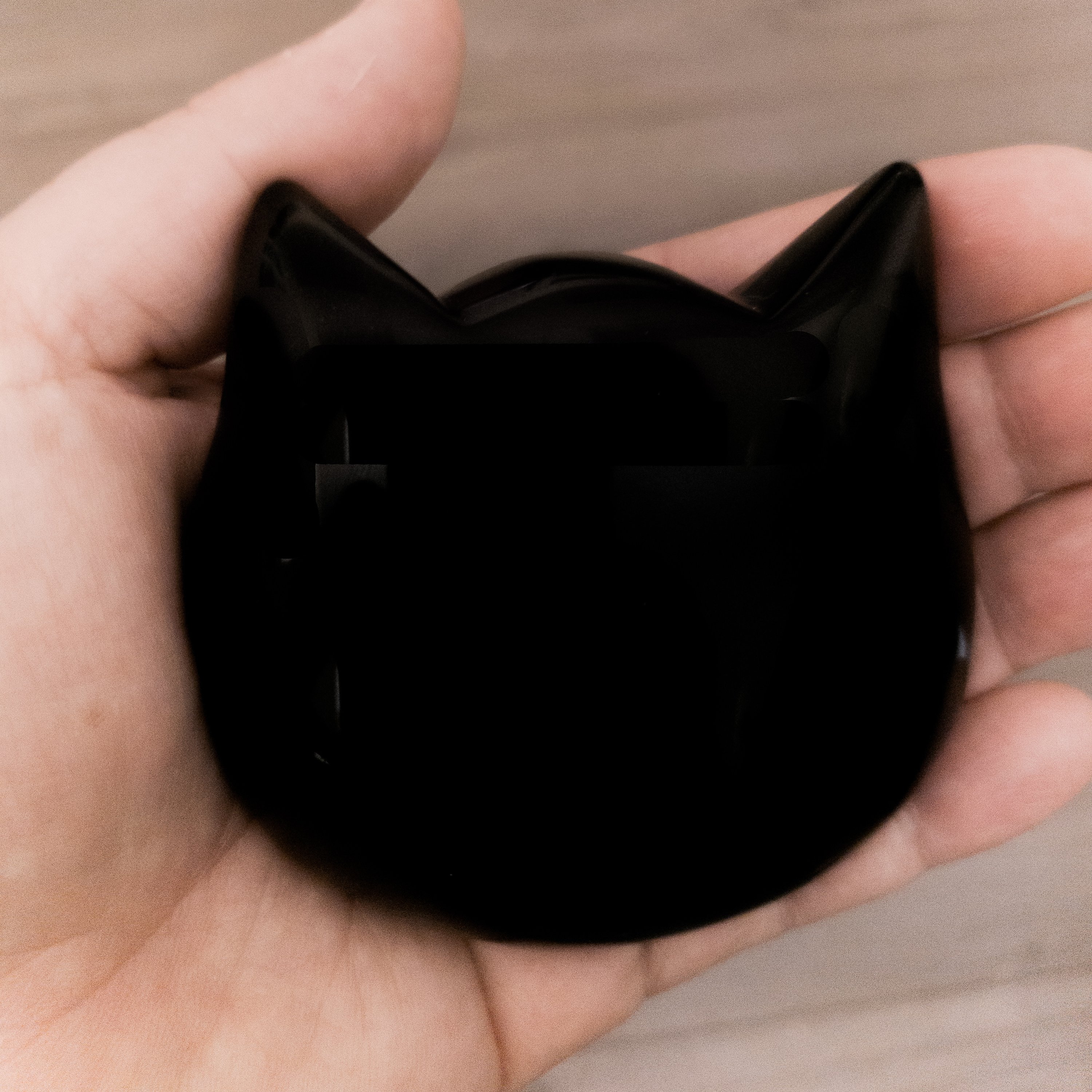 Three hand-polished Puffy Crystal Cat Heads in Black Obsidian, Rose Quartz, and Clear Quartz, showcasing their unique shapes and colors.