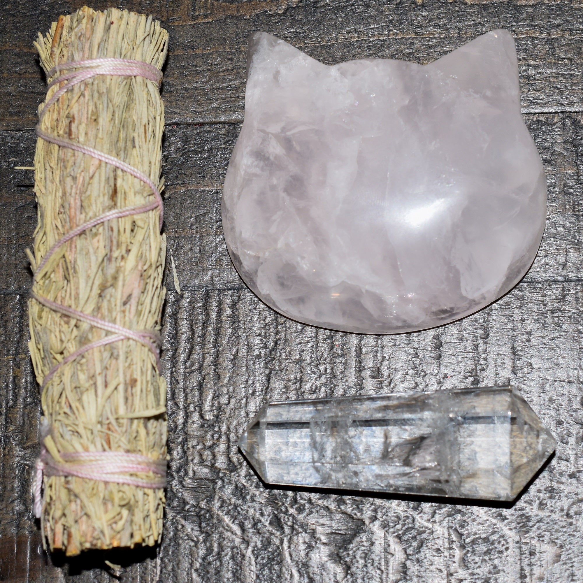 Three hand-polished Puffy Crystal Cat Heads in Black Obsidian, Rose Quartz, and Clear Quartz, showcasing their unique shapes and colors.