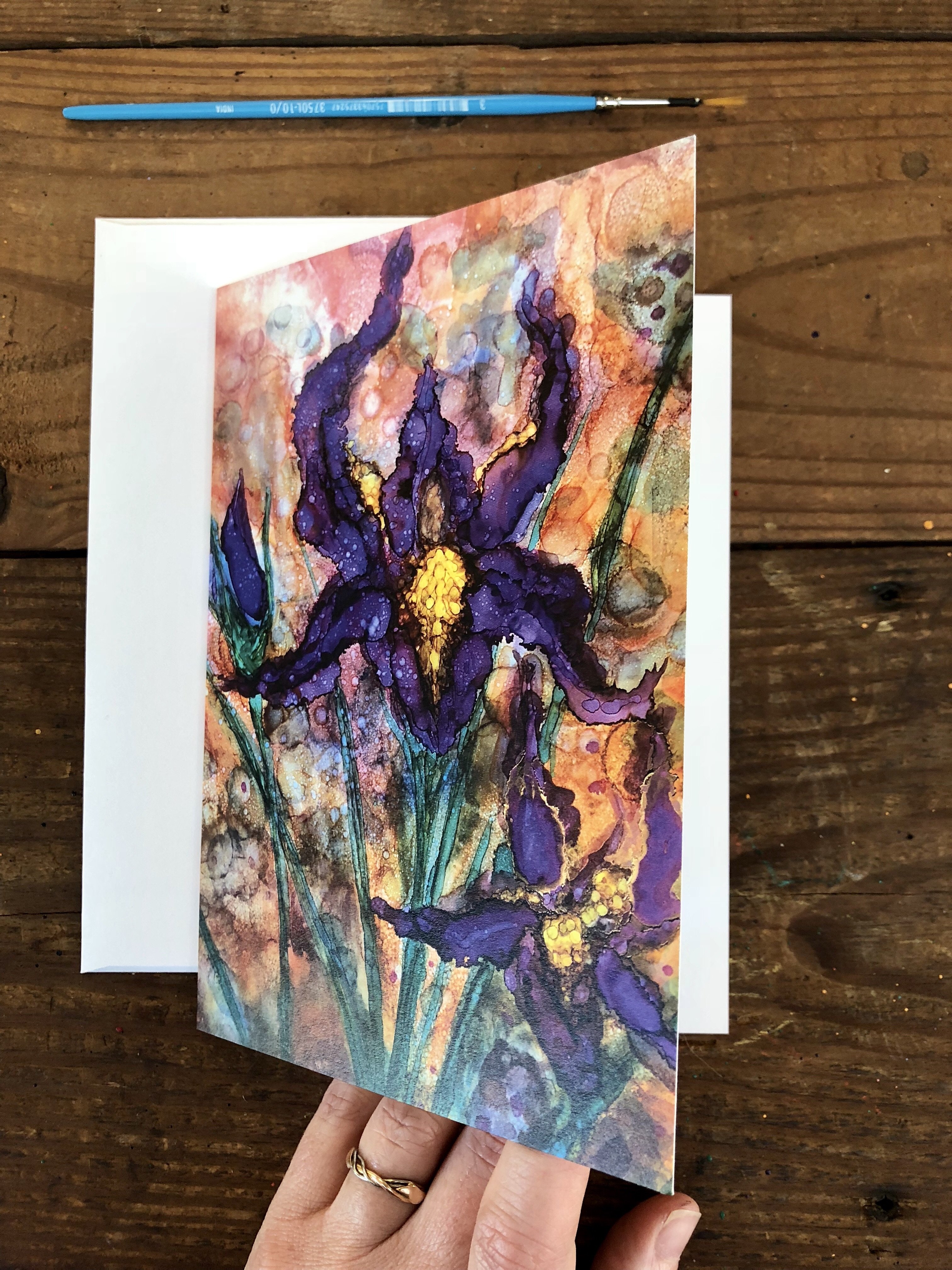 A beautifully designed greeting card featuring vibrant purple irises against a detailed background, showcasing intricate details and soothing colors.