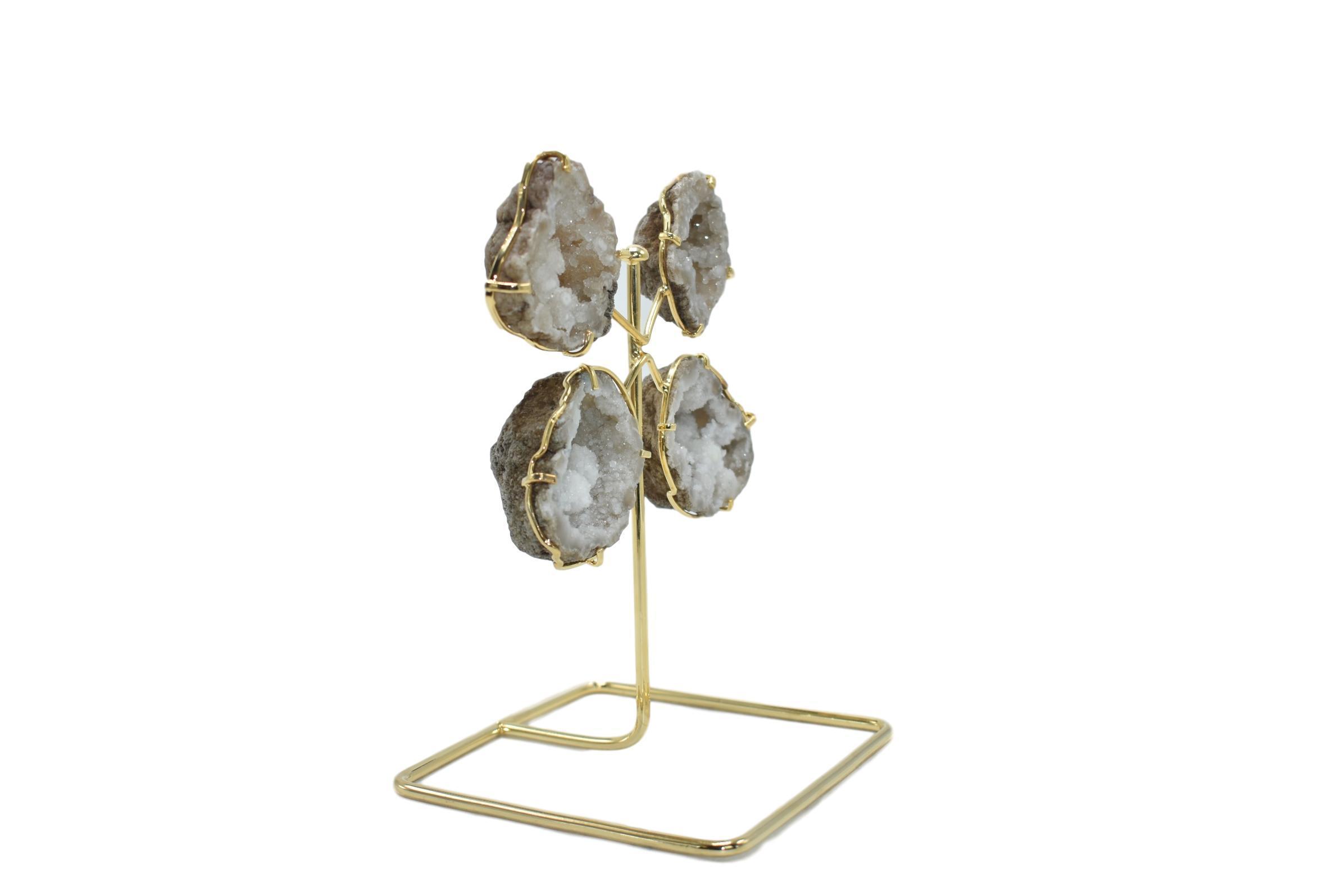 A stunning quartz geode from Morocco displayed on a golden wire stand, showcasing its natural crystal formations and elegant design.