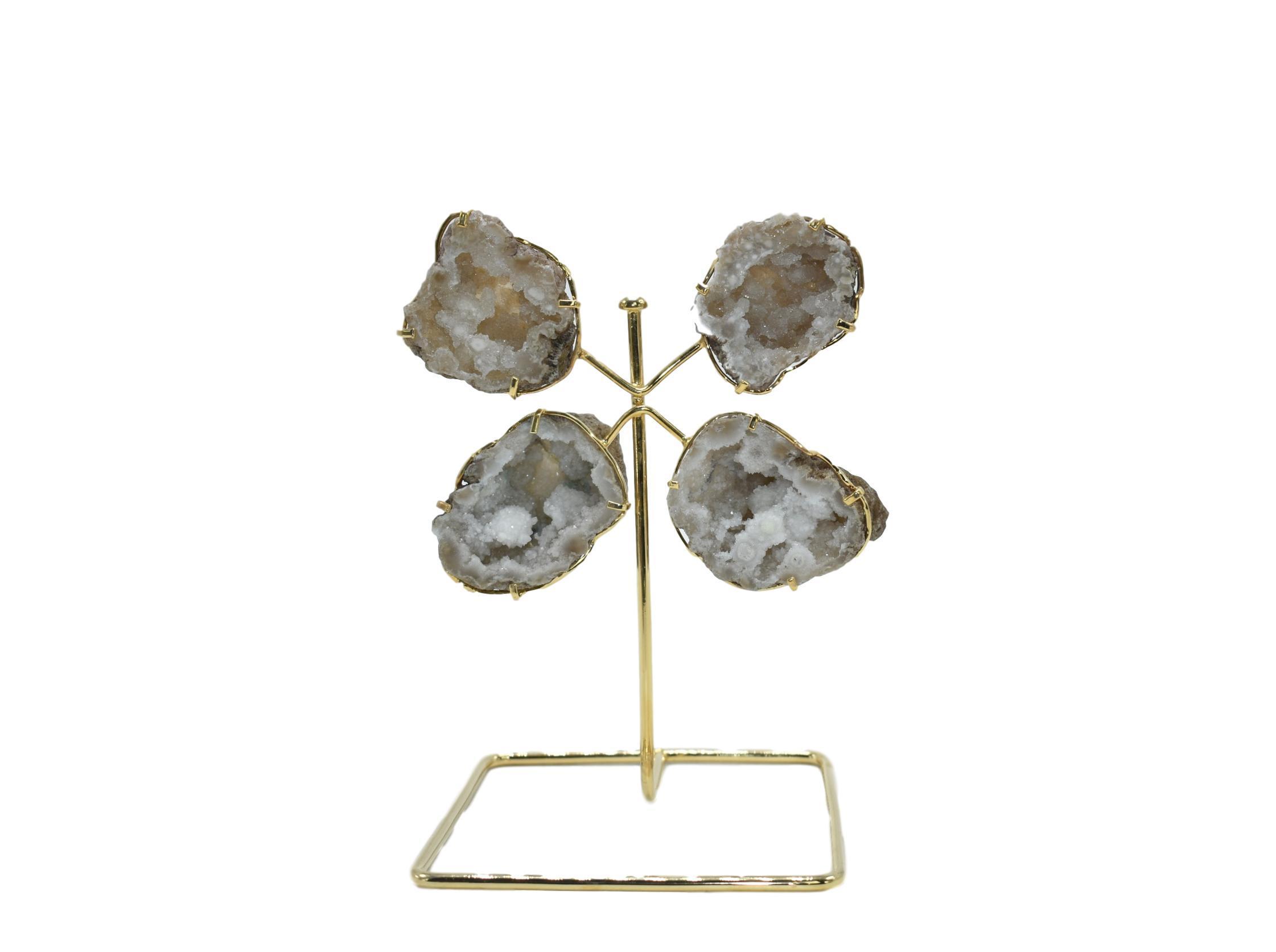 A stunning quartz geode from Morocco displayed on a golden wire stand, showcasing its natural crystal formations and elegant design.