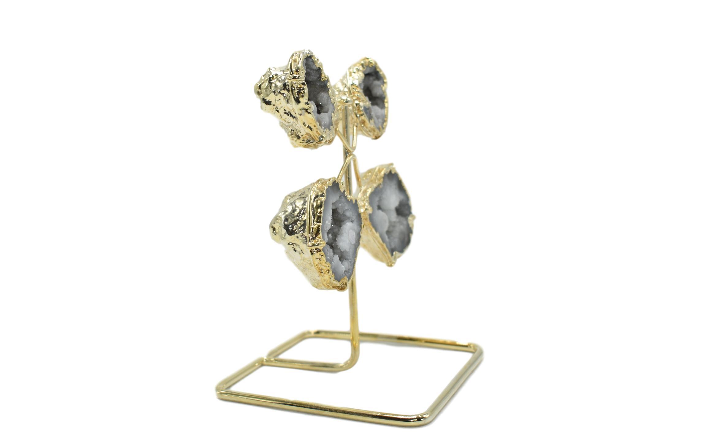 A stunning quartz geode from Morocco displayed on a golden wire stand, showcasing its natural crystal formations and elegant design.