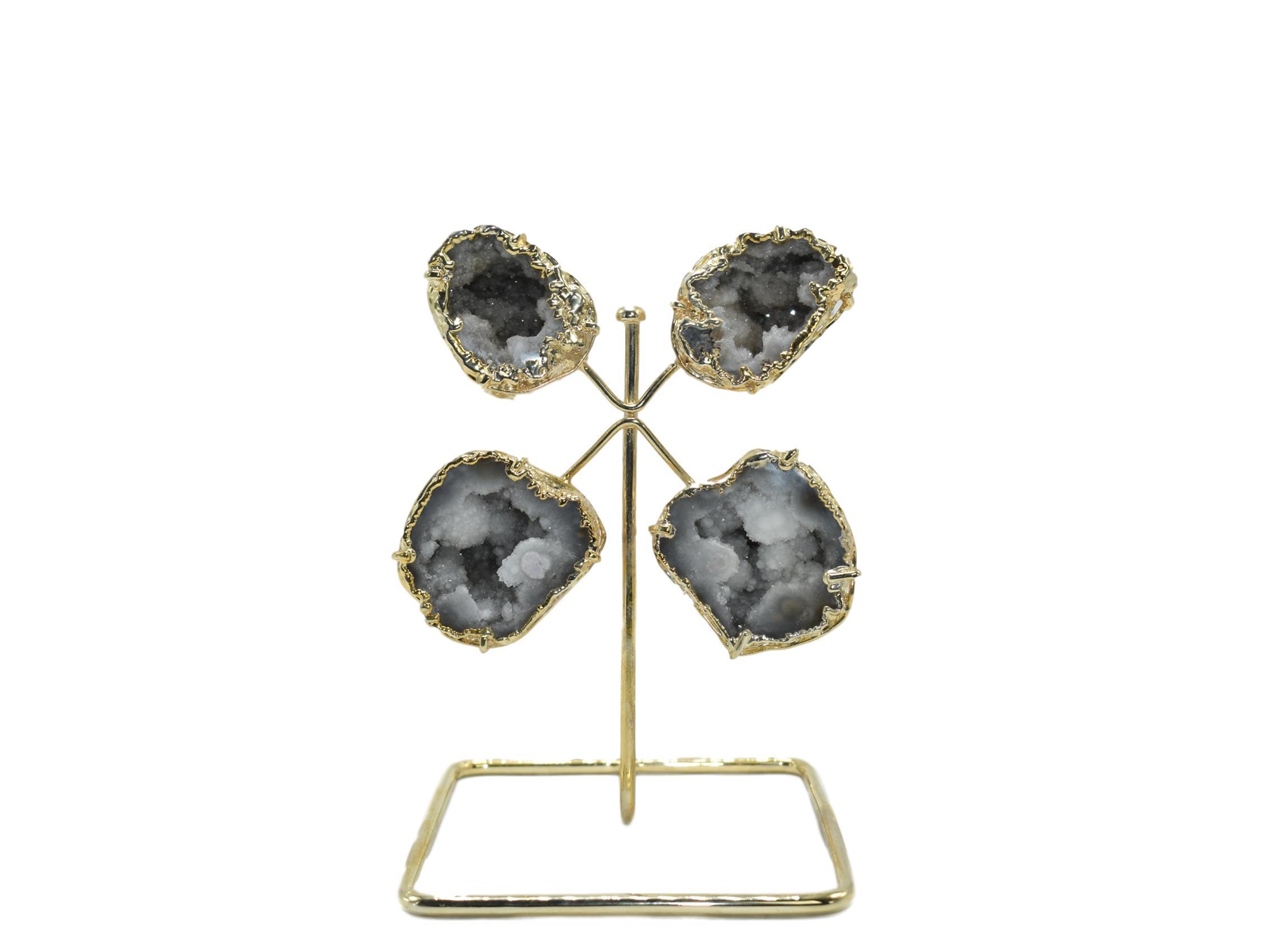 A stunning quartz geode from Morocco displayed on a golden wire stand, showcasing its natural crystal formations and elegant design.