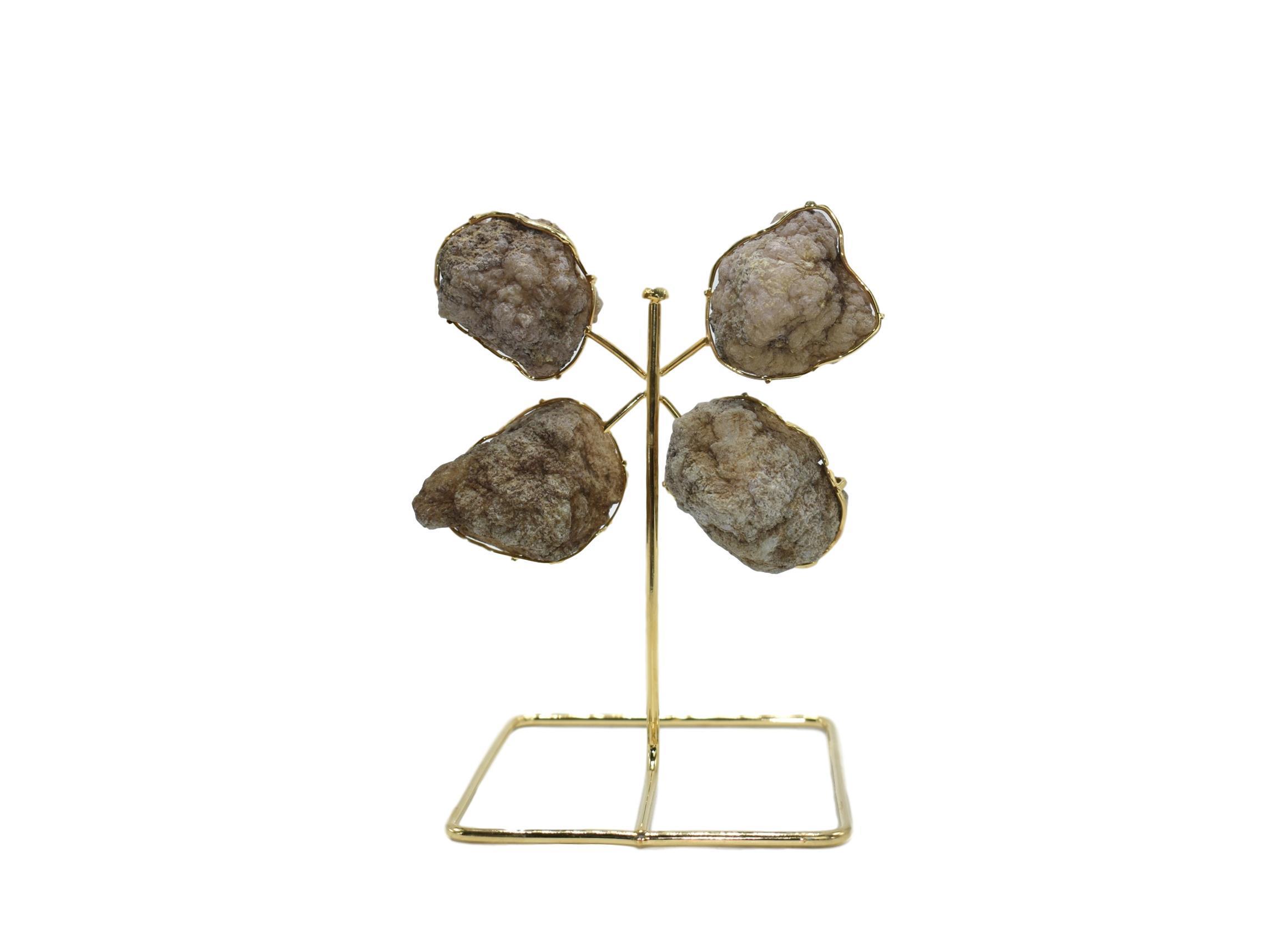 A stunning quartz geode from Morocco displayed on a golden wire stand, showcasing its natural crystal formations and elegant design.