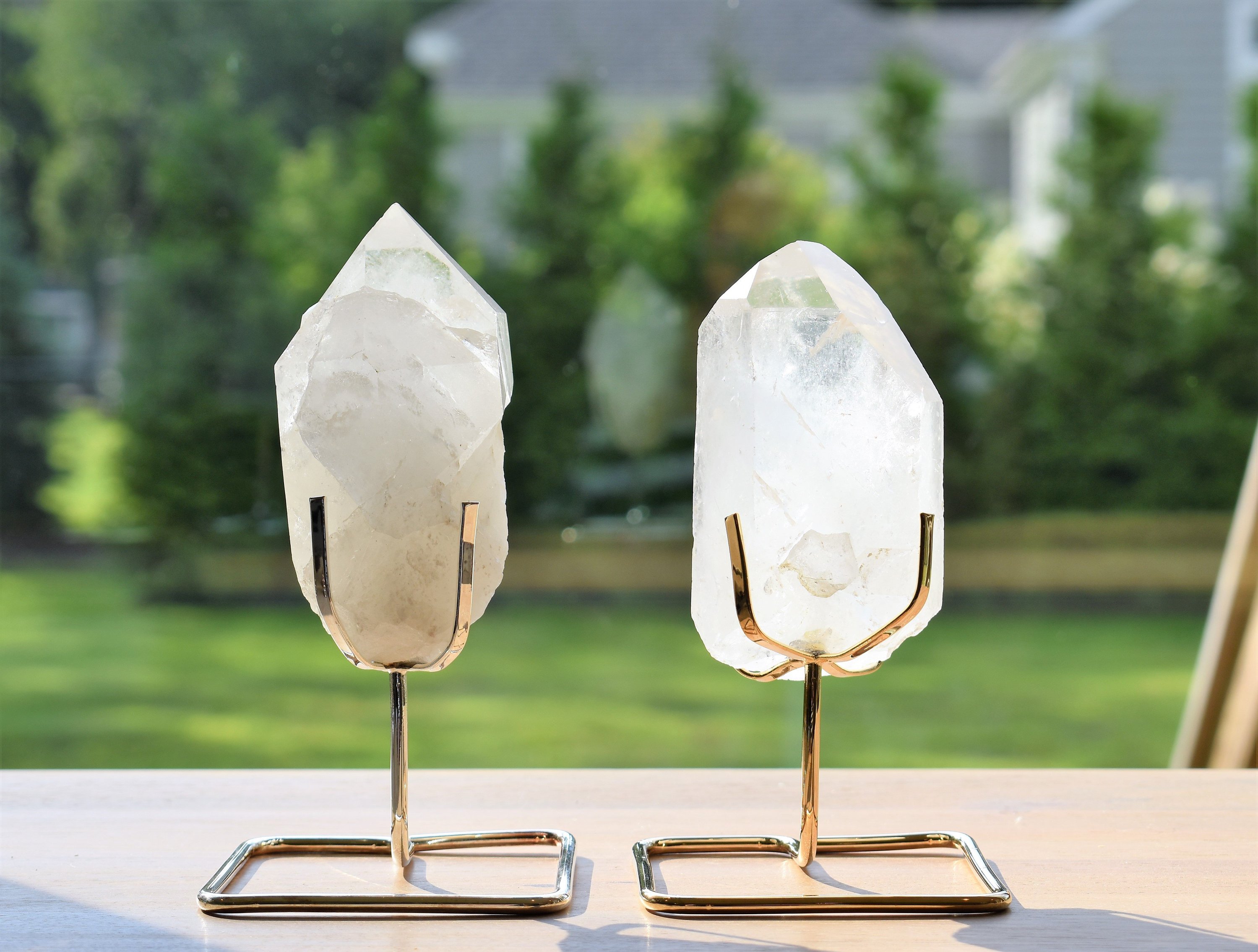 A beautiful quartz point displayed on a sturdy wire stand, available in gold and silver finishes, enhancing home decor.