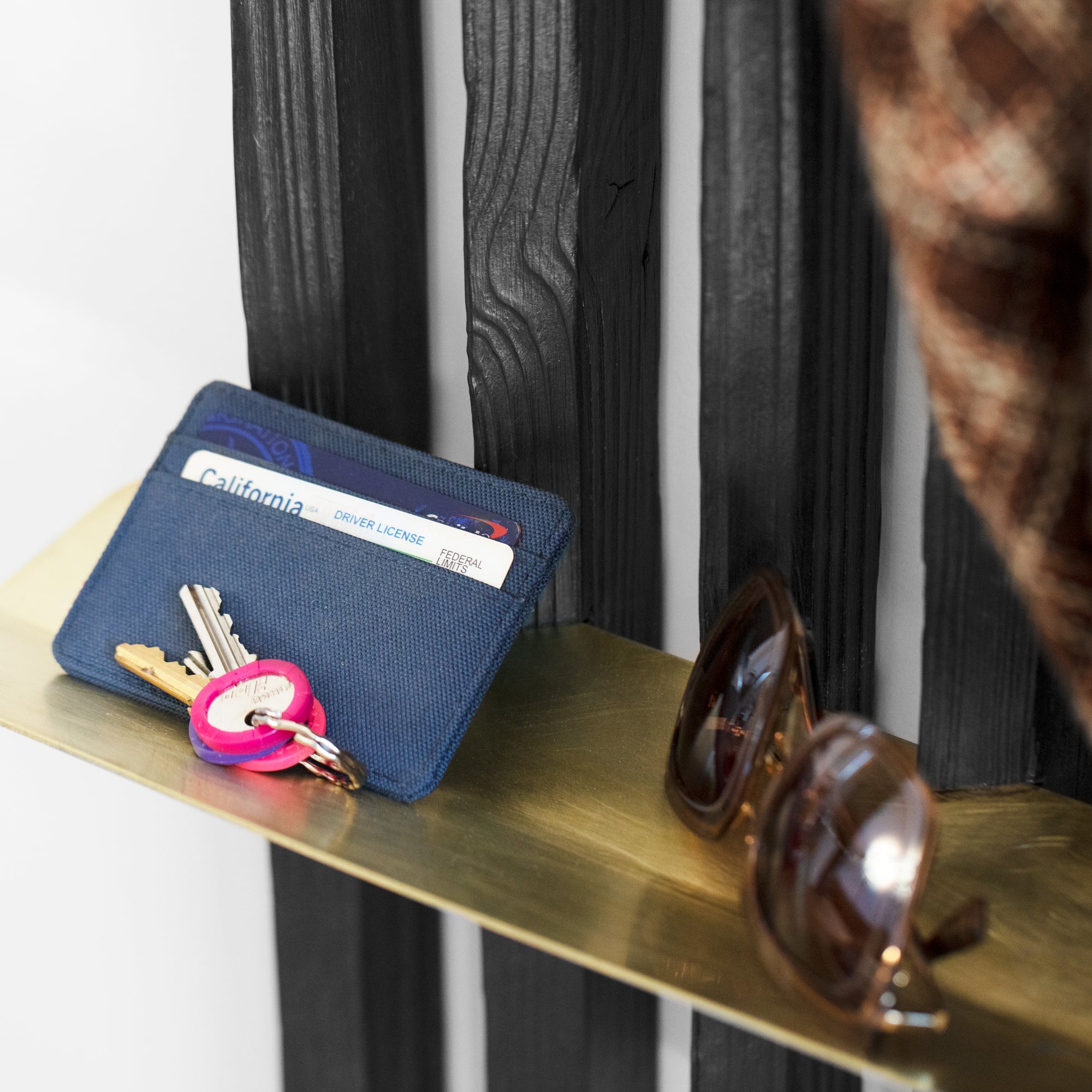 Rack On coat rack featuring hooks and a brass tray, made from reclaimed wood with a torched black finish.