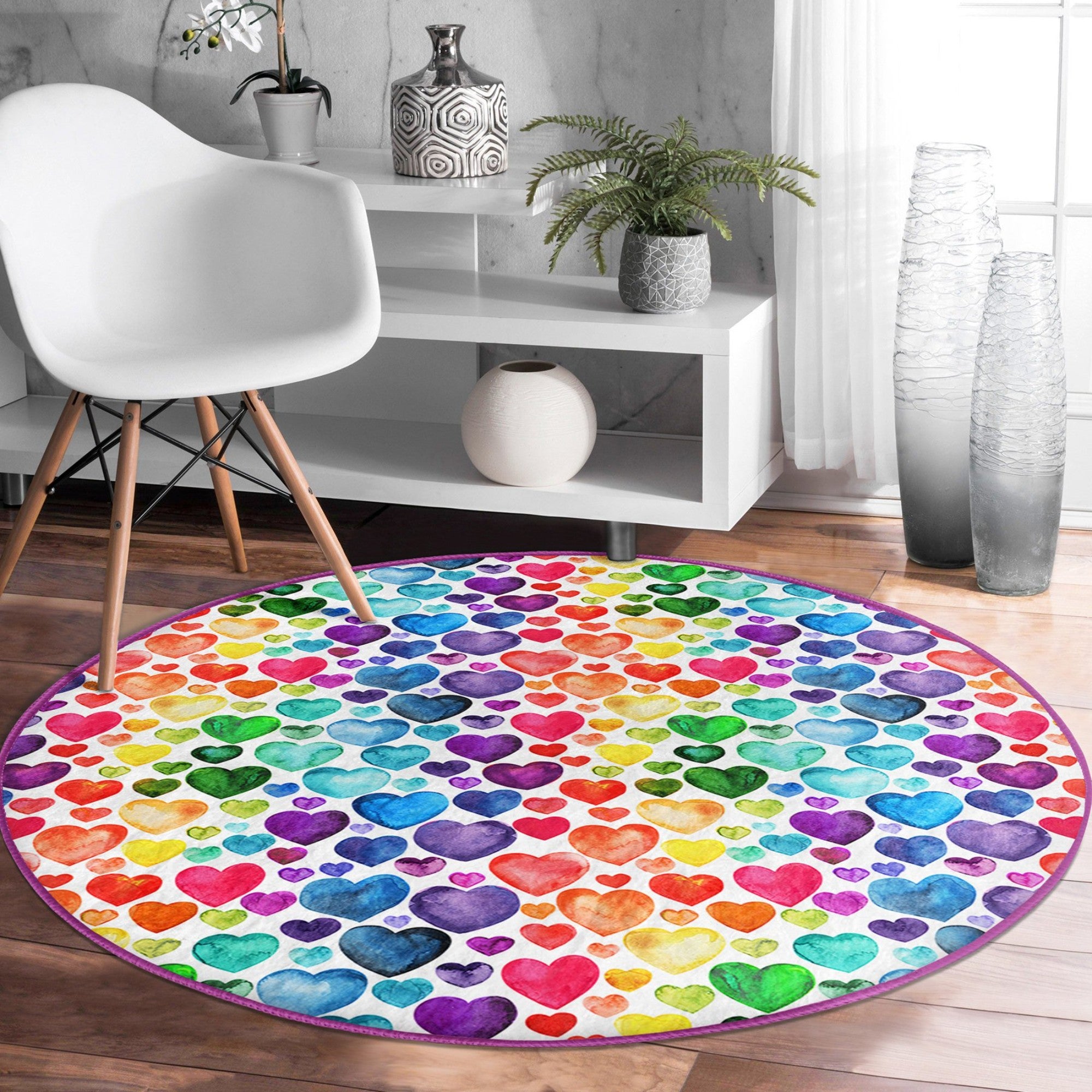 A colorful round rug featuring a vibrant rainbow heart pattern, perfect for home decor.