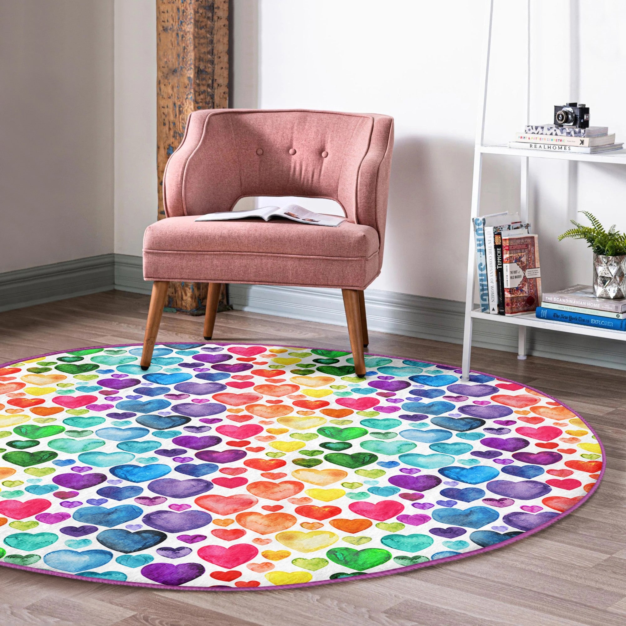 A colorful round rug featuring a vibrant rainbow heart pattern, perfect for home decor.