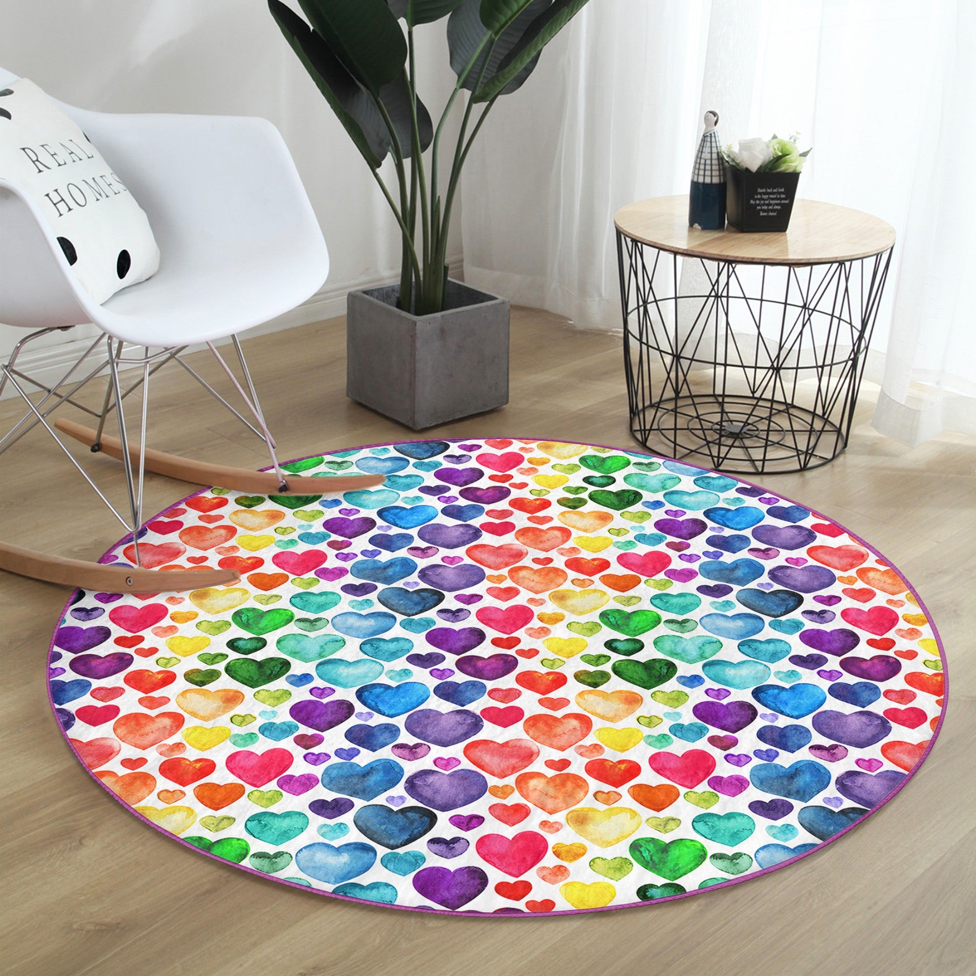 A colorful round rug featuring a vibrant rainbow heart pattern, perfect for home decor.