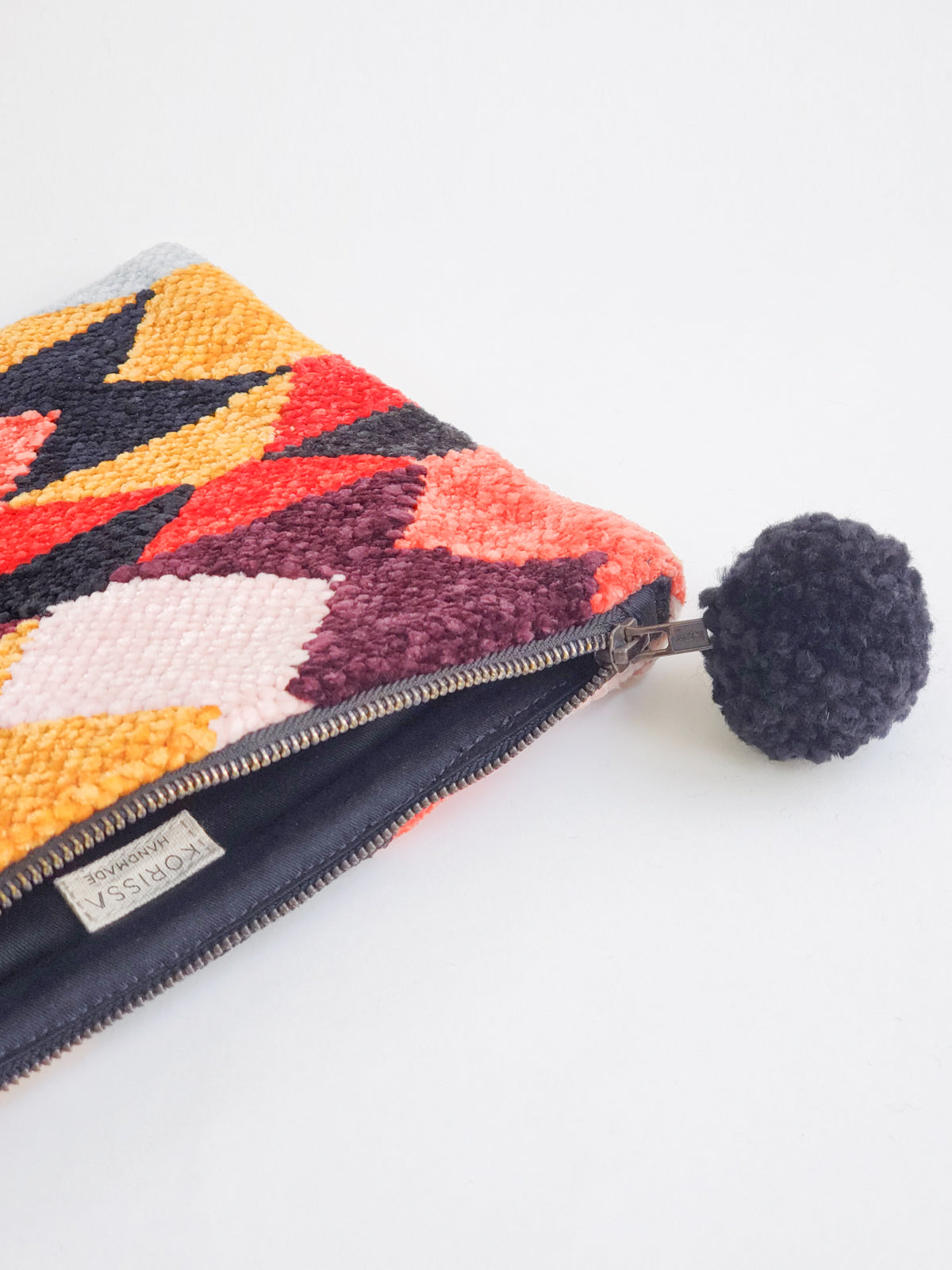 Rana Clutch made from recycled chenille fabric, featuring vibrant colors and unique patterns, perfect for fall and winter.