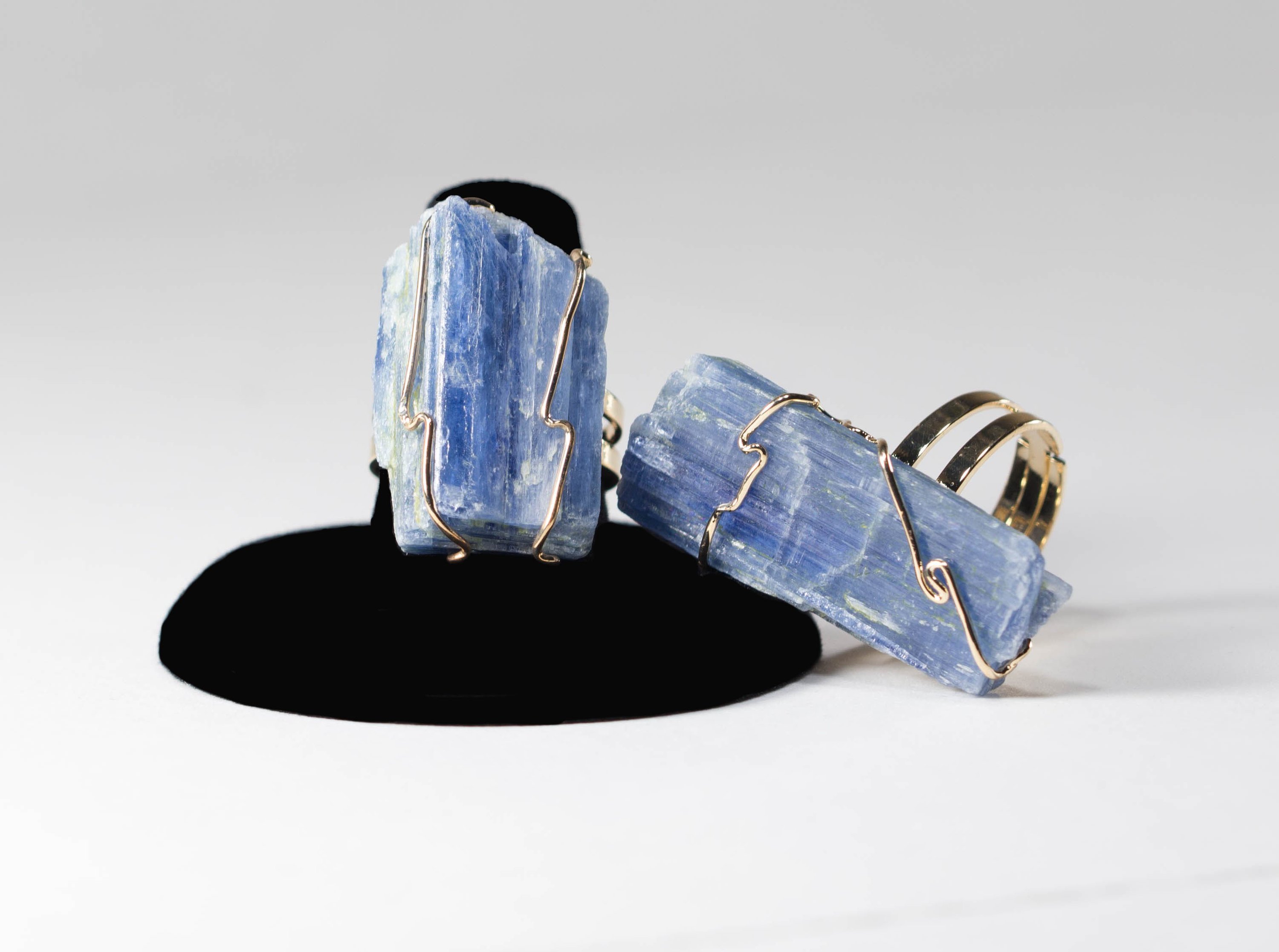 A handcrafted Raw Kyanite Ring featuring a tranquil blue kyanite stone wrapped in gold or silver wire, showcasing unique natural patterns.