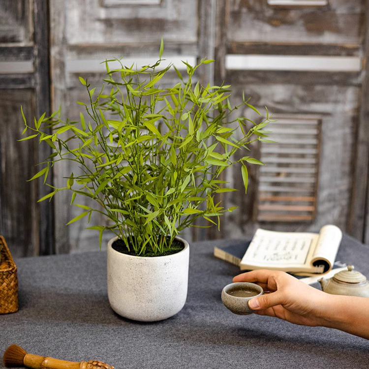 Realistic Mini Bamboo Leaf Potted Plant in a light gray pot, showcasing vibrant green leaves and a lifelike appearance.