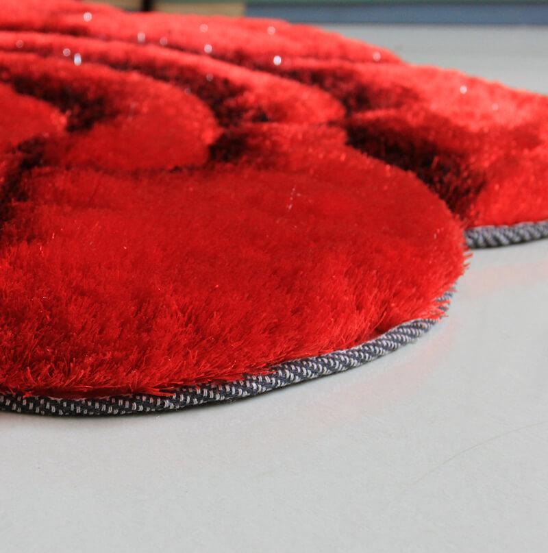 A plush red and black flower decorative rug with a shaggy texture, featuring a vibrant floral design, perfect for enhancing home decor.