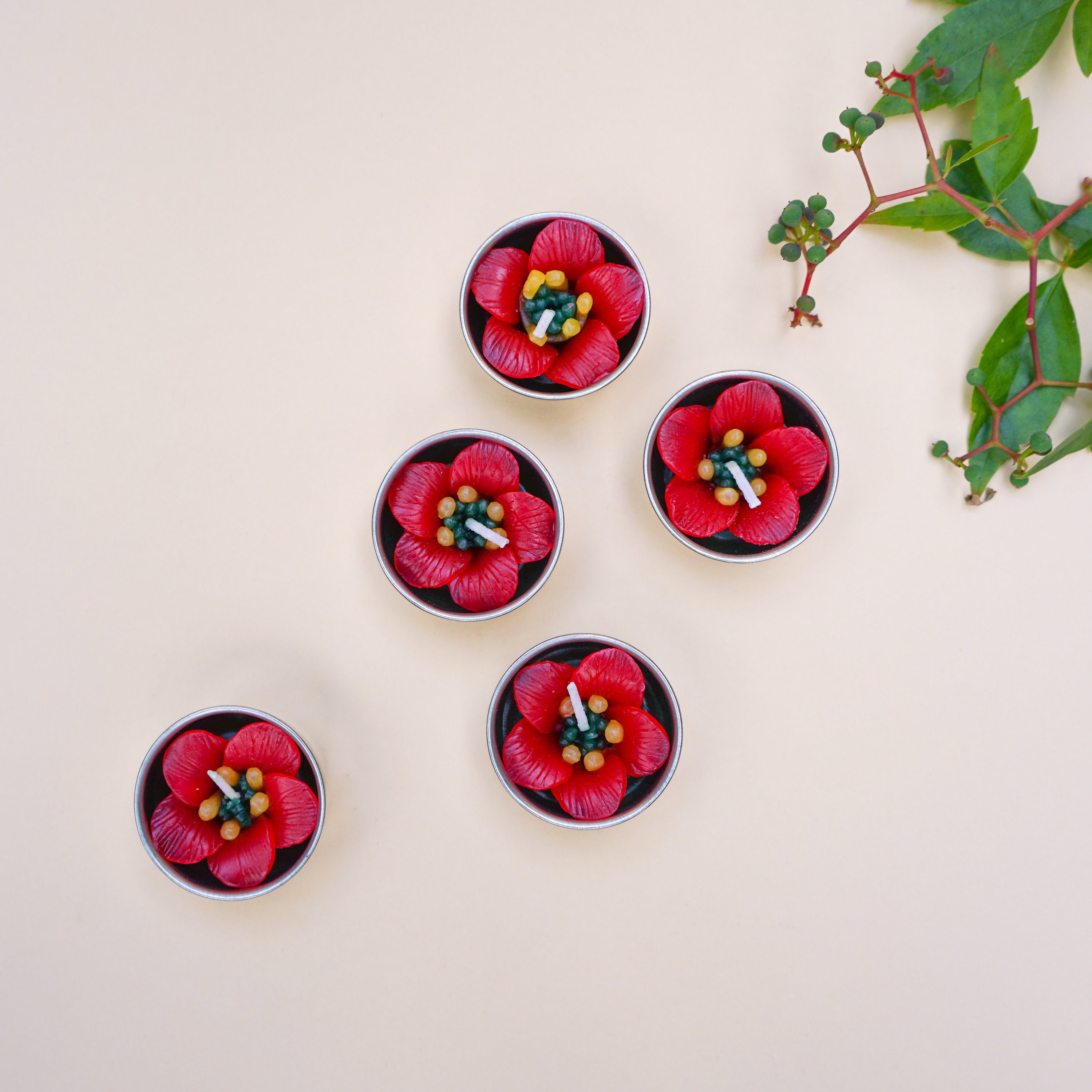 A set of Red Escallonia Scented Tealights featuring five round petals, handmade in vibrant red, with a soothing Indian jasmine fragrance.