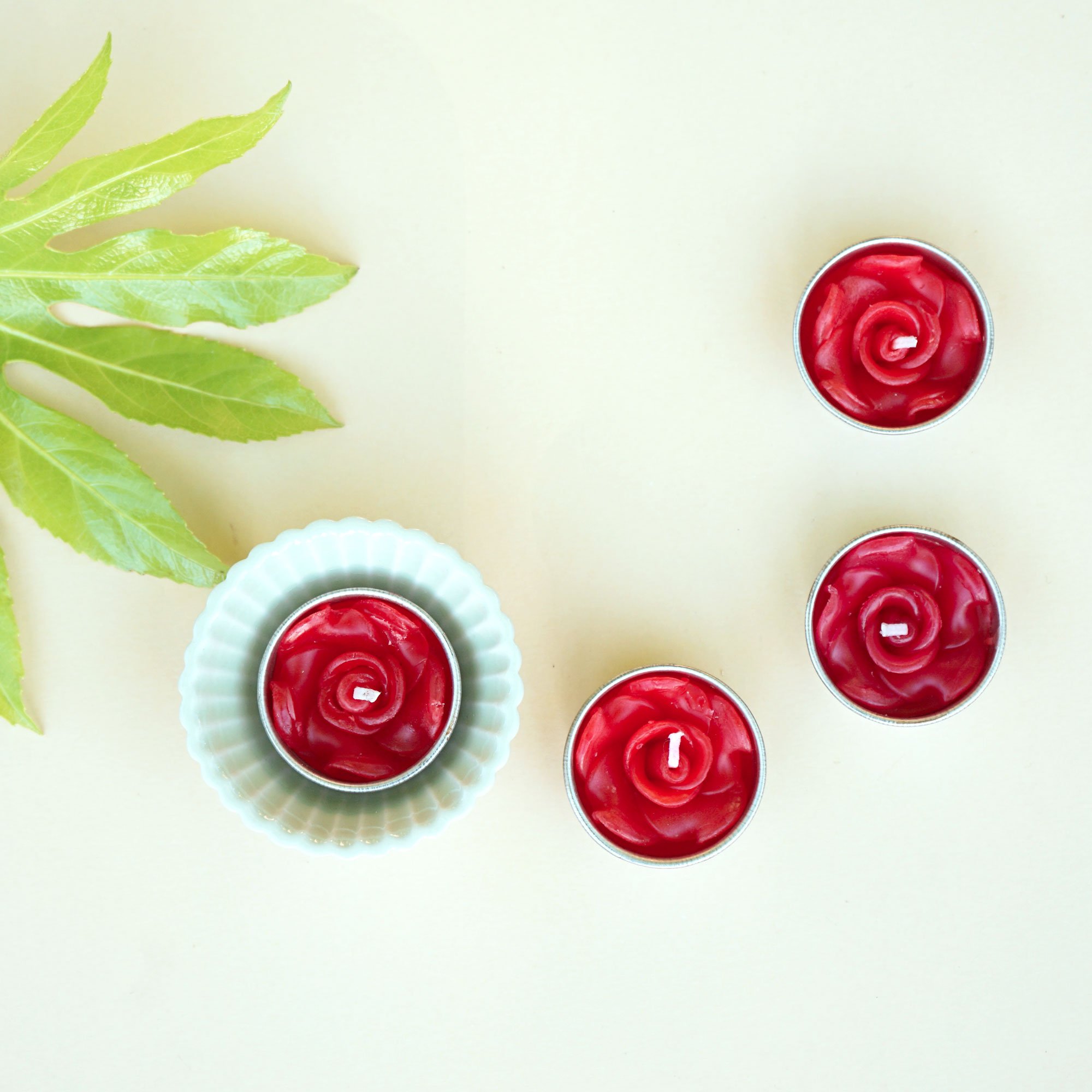 A set of eight red rose scented tealights in a decorative botanic garden printed box, showcasing their elegant design and vibrant color.