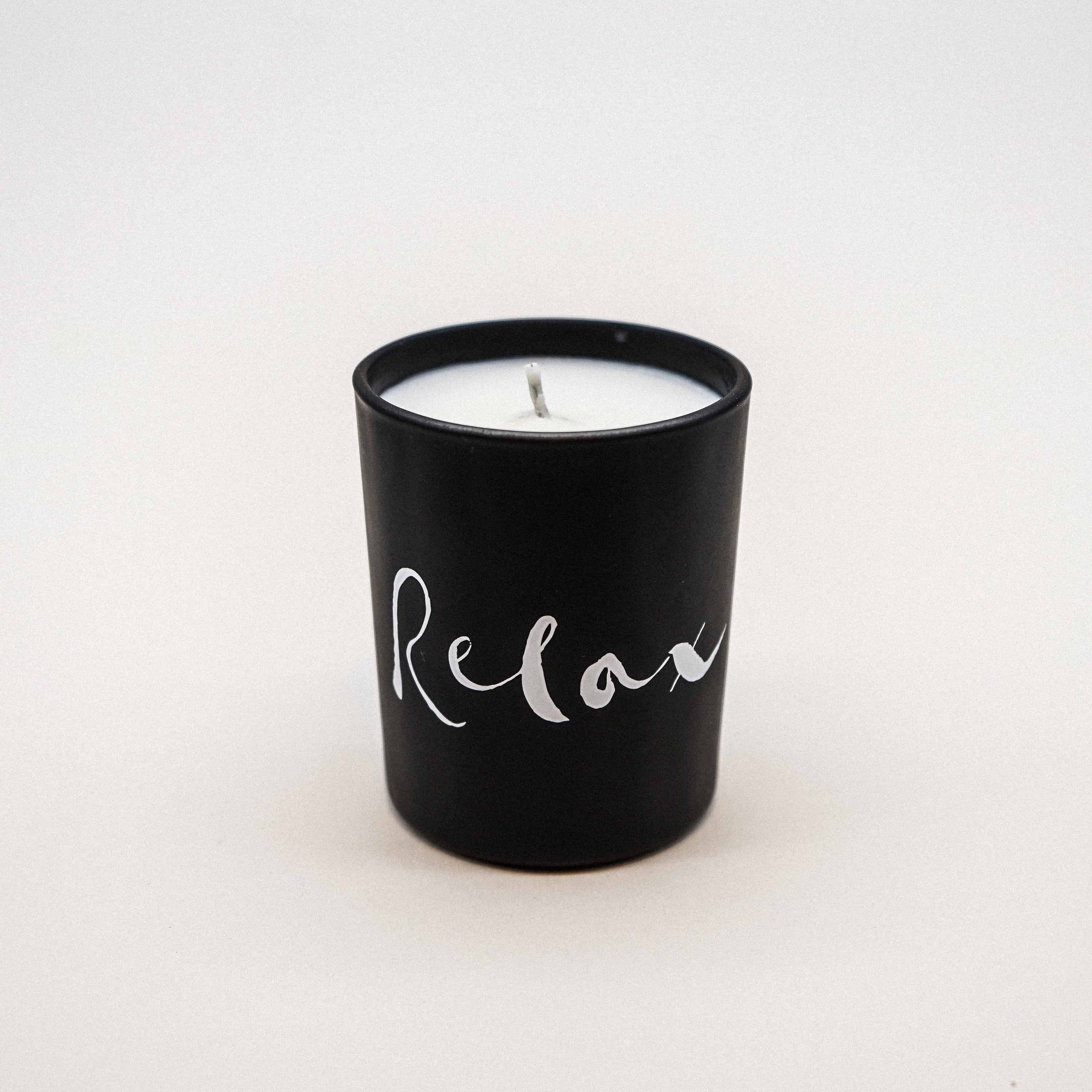 Relax Natural Wax Candle in black glass with brush painting design, showcasing its elegant and soothing appearance.