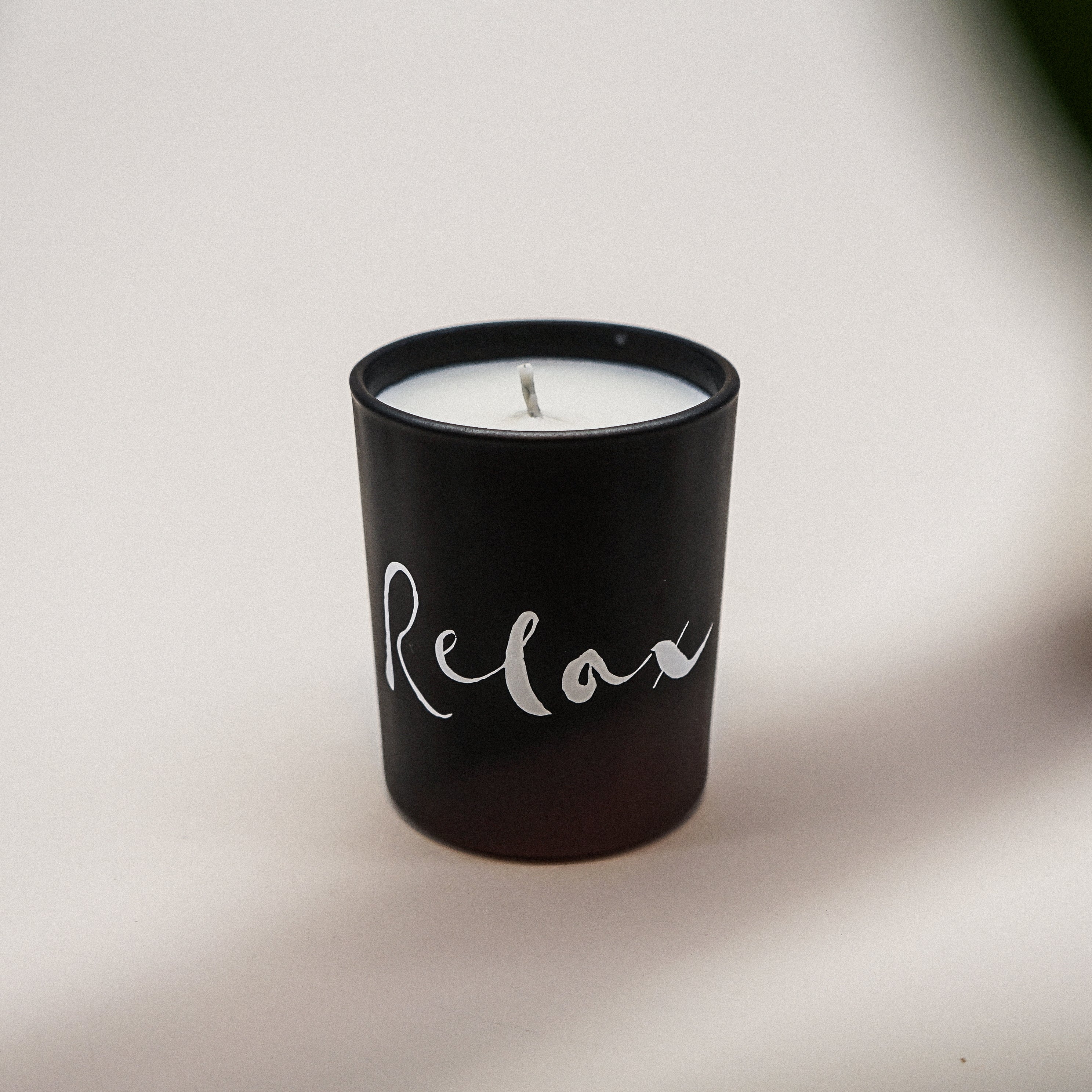 Relax Natural Wax Candle in black glass with brush painting design, showcasing its elegant and soothing appearance.