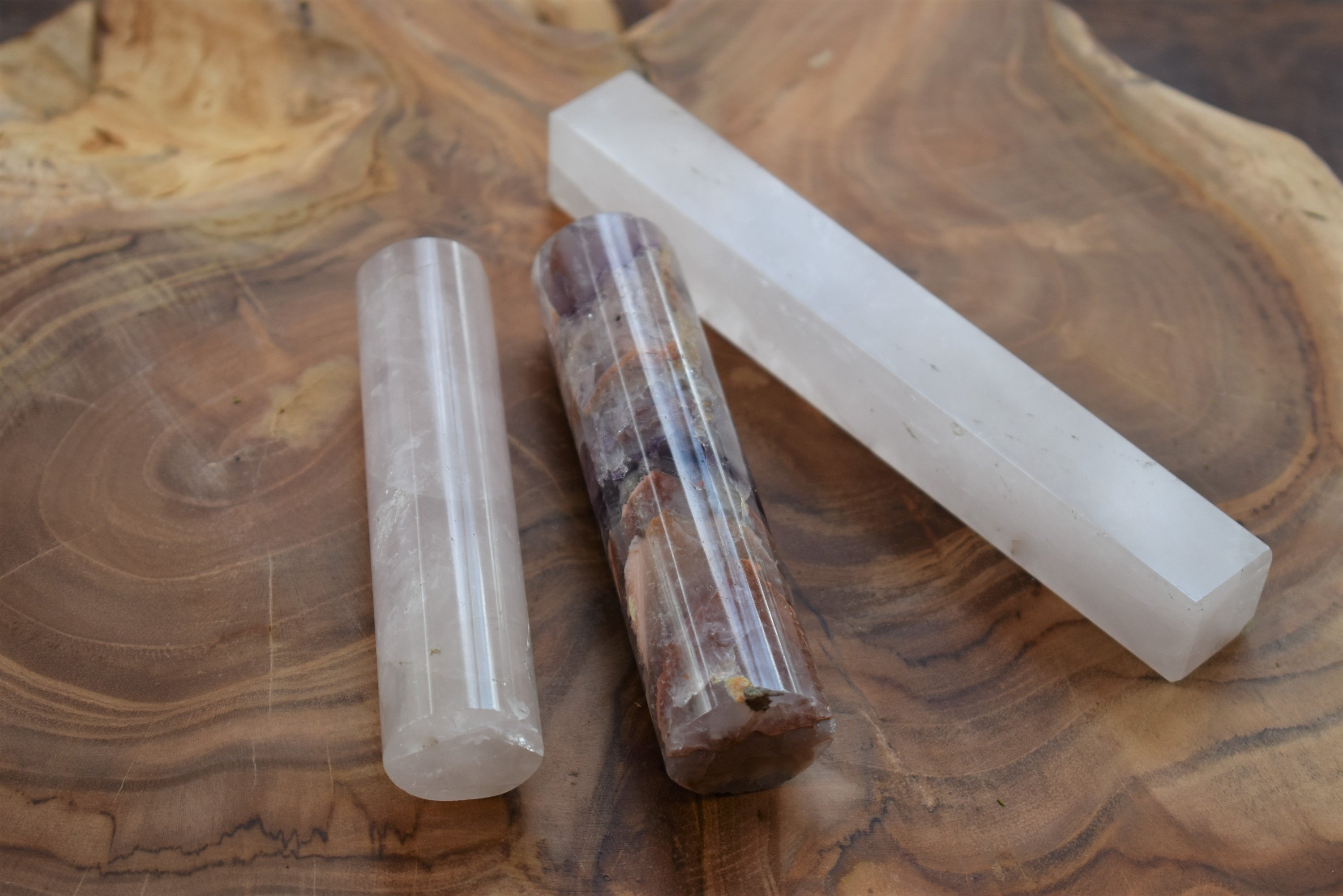 A collection of 4-inch gemstone rods made from amethyst, rose quartz, and clear quartz, showcasing their natural beauty and vibrant colors.