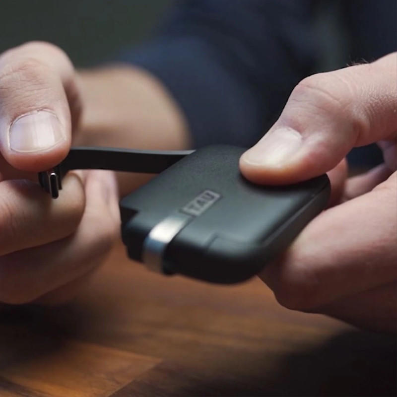 ROLLINGSQUARE Tau Black power bank, the world's smallest 3-in-1 charger for iPhone, Micro USB, and USB-C, attached to a keychain.