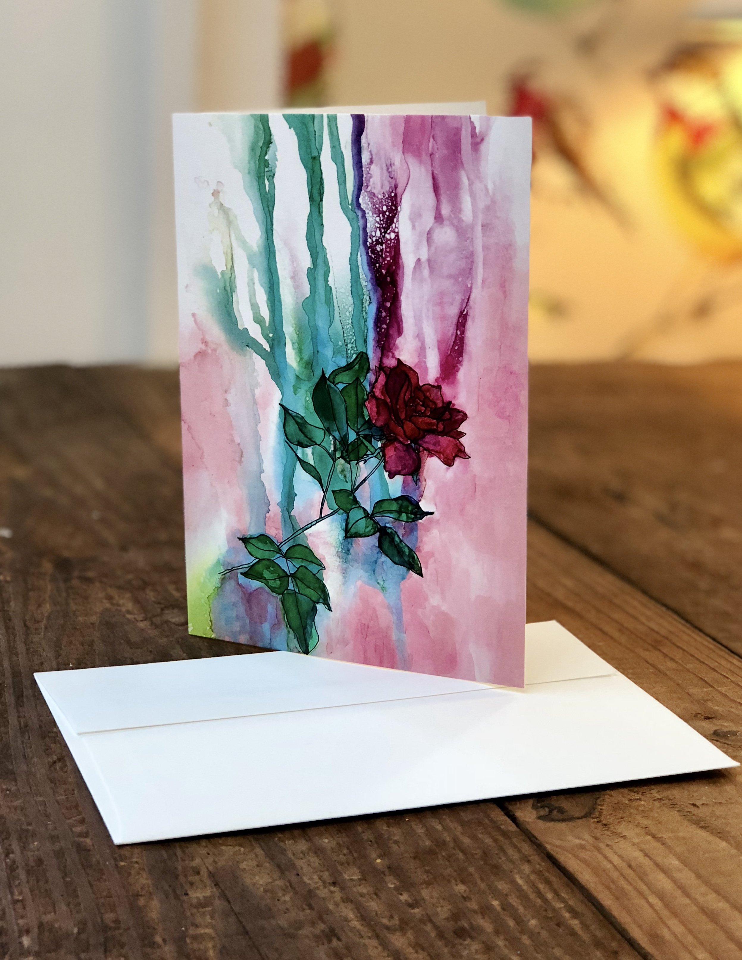 A delicate pink rose greeting card featuring a hand-drawn rose design, printed on heavyweight matte paper with a white envelope.