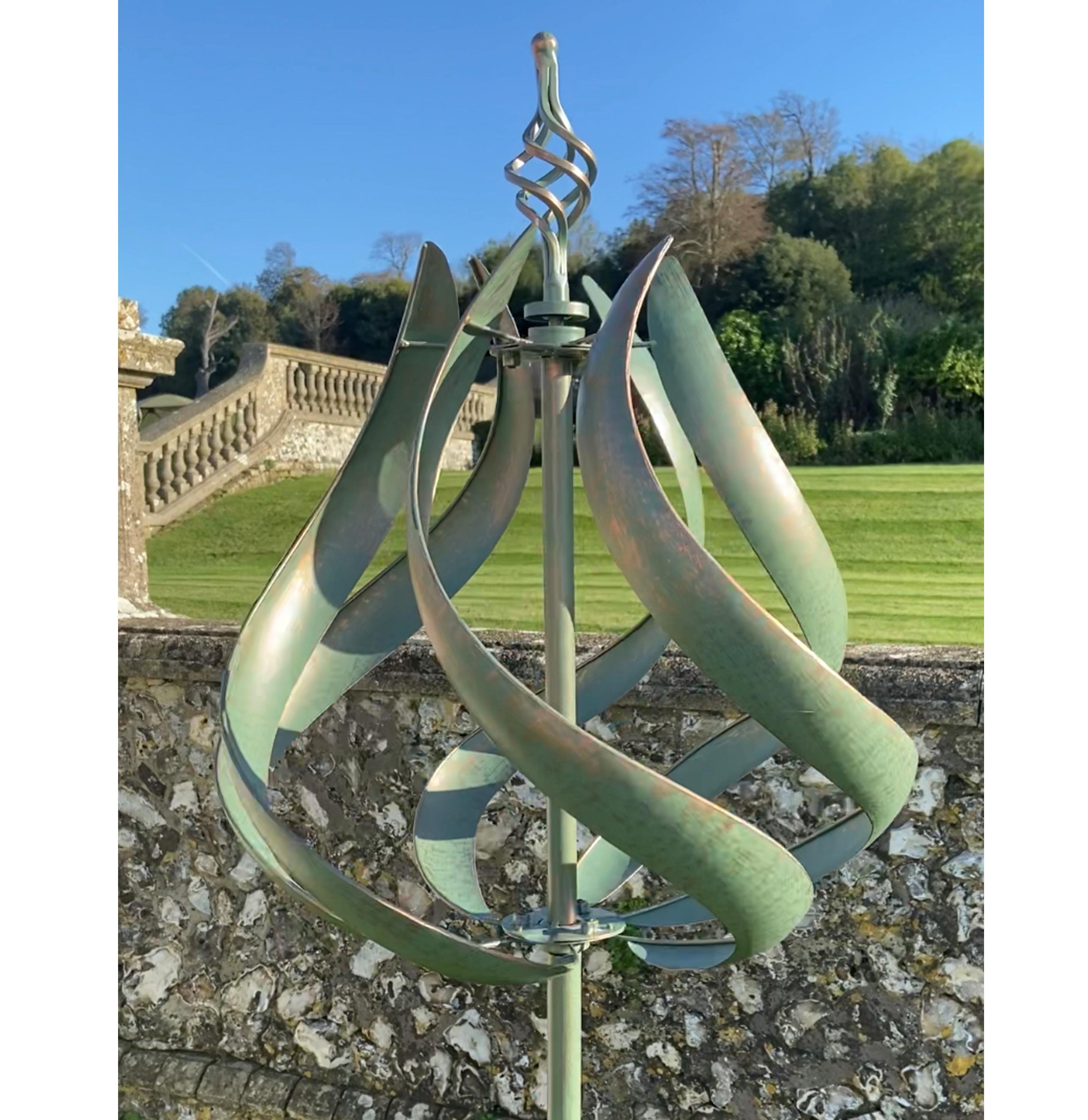 Roseland verdigris garden wind sculpture spinner with two-tone color, standing tall in a garden setting.