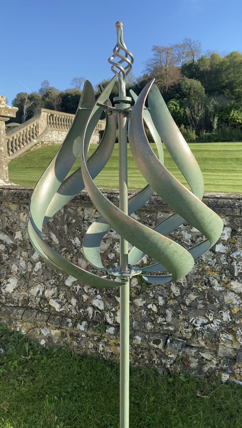 Roseland verdigris garden wind sculpture spinner with two-tone color, standing tall in a garden setting.