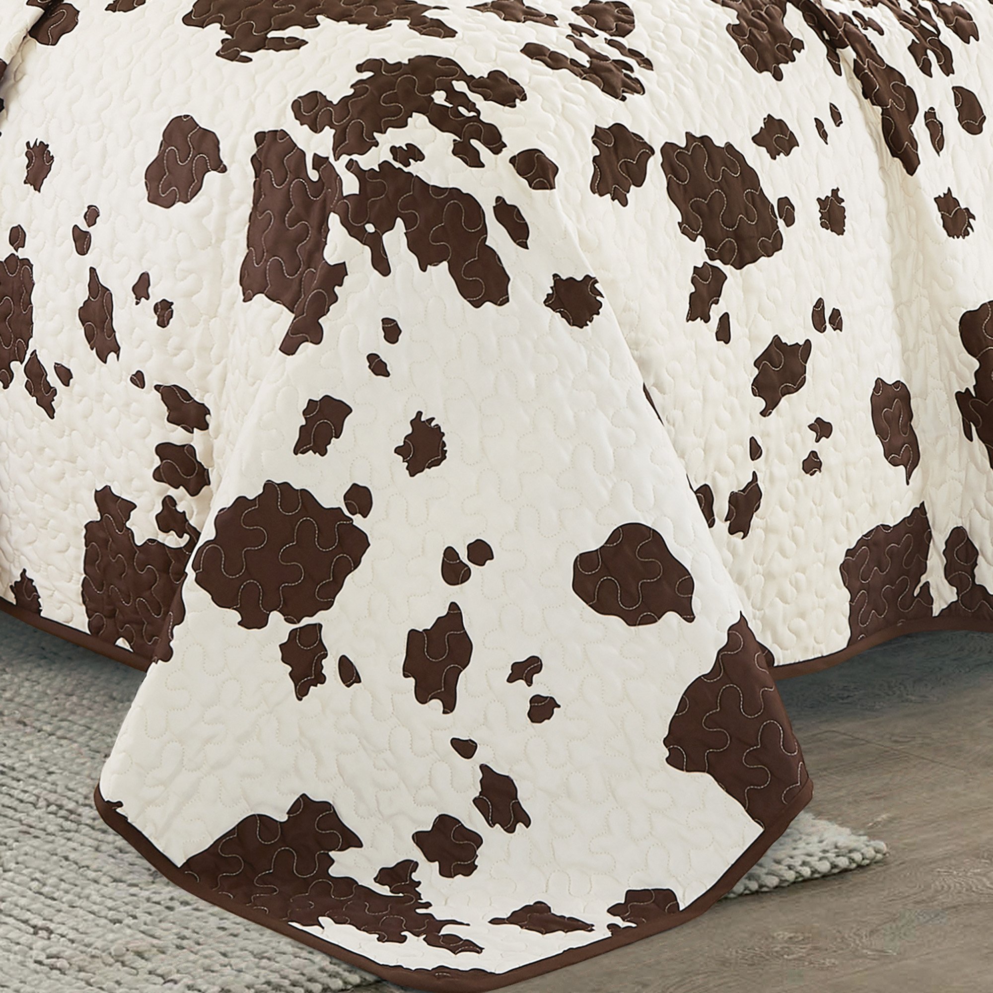 Rustic Cowhide Brown Cow Skull Quilt Set featuring a luxurious bedspread, pillow shams, and decorative pillows in a Western design.