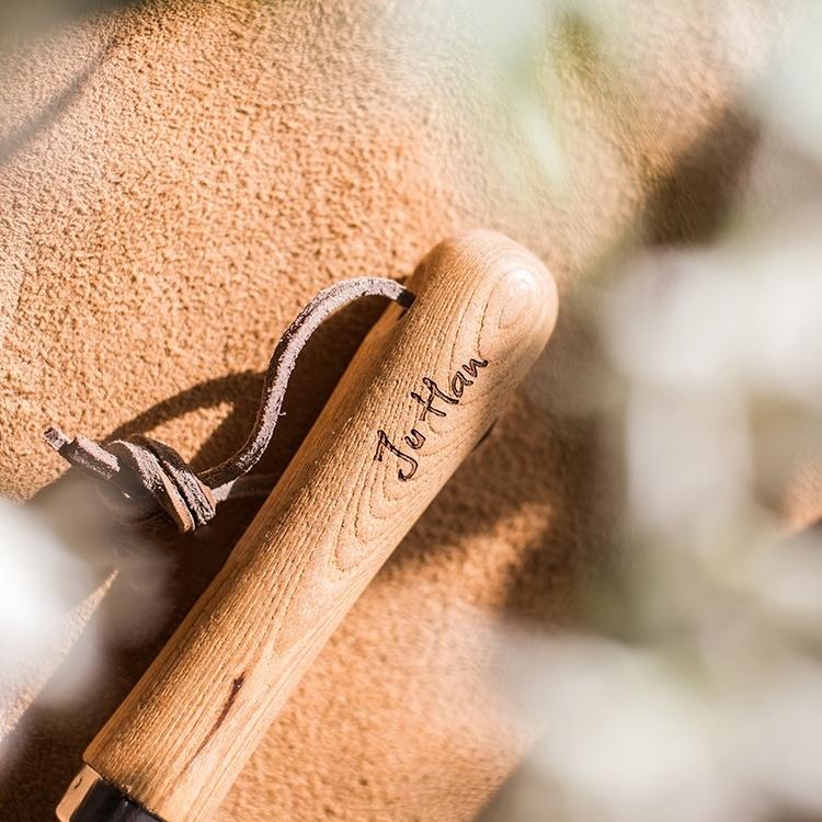 Rustic style pruning shears and gardening tools with wooden handles and stainless steel blades, arranged on a wooden surface.